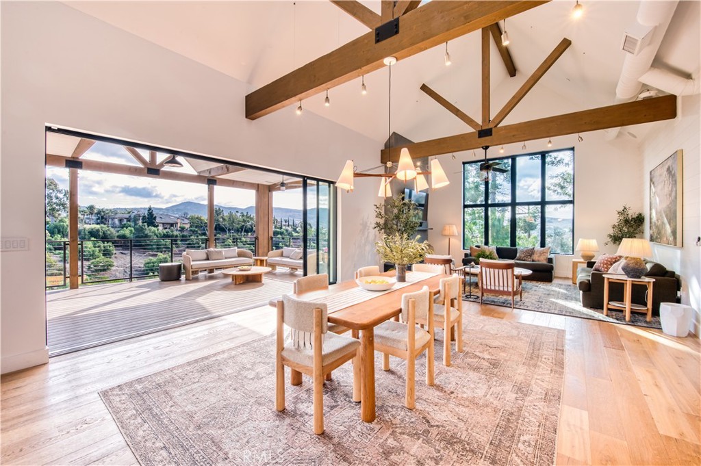 This stunning modern farmhouse estate, set on 2.46 acres, offers the perfect balance of rural serenity and contemporary luxury. Enjoy the best of both worlds—a peaceful sanctuary just moments away from the coast, O'Neill Regional Park, downtown San Juan Capistrano and major transportation routes. Built in 2018 with exceptional craftsmanship, the main residence spans 3,188 sq ft. and features 3 spacious bedrooms plus a versatile den, which can easily be used as a 4th bedroom. Each bedroom includes its own ensuite bath, ensuring ultimate comfort and privacy. Designed to maximize breathtaking hillside views, this home includes expansive wraparound decks with custom lighting, ceiling fans, heat lamp, a built-in bar creating an ideal setting for outdoor entertaining. Inside, the open-concept design with soaring open-beamed ceilings and oversized windows floods the living spaces with natural light, framing stunning vistas of the surrounding landscape. The home boasts wide-plank white oak flooring, remote-controlled vented skylights, and a chef’s kitchen complete with high-end appliances, quartz countertops, and a spacious yet smartly hidden butler’s pantry equipped with a second fridge & freezer. In addition to the main residence, the property features a 3 level 1,005 sq. ft. studio/loft ADU barn. The barn includes a top of the line 3.5 BBL craft brewery/winery that is currently licensed by California ABC and Federal TTB, offering a potential income opportunity. The brewery/winery area can also easily be converted to temperature-controlled stables for equestrian accommodations, among many other recreational uses. The barn garage has built-in commercial air compressor, pressure washer, and nitrogen generator. Adjacent to the main home, a charming 551 sq. ft. carriage house offers a studio loft, kitchenette, full bathroom, private deck with sweeping views, and a 2-car garage with an EV outlet. Smart-Home technology enhances this estate, allowing seamless control of lighting, security, landscape watering and climate control. Additional modern amenities include dual-pane windows, central air conditioning, and a dog wash station in the laundry area. Designed in collaboration with McRae, Lambert, and Dunn, this home has earned recognition in renowned interior design publications, highlighting its timeless elegance. This is a rare opportunity to own a home that embodies both modern luxury and country charm, offering a lifestyle that’s second to none.