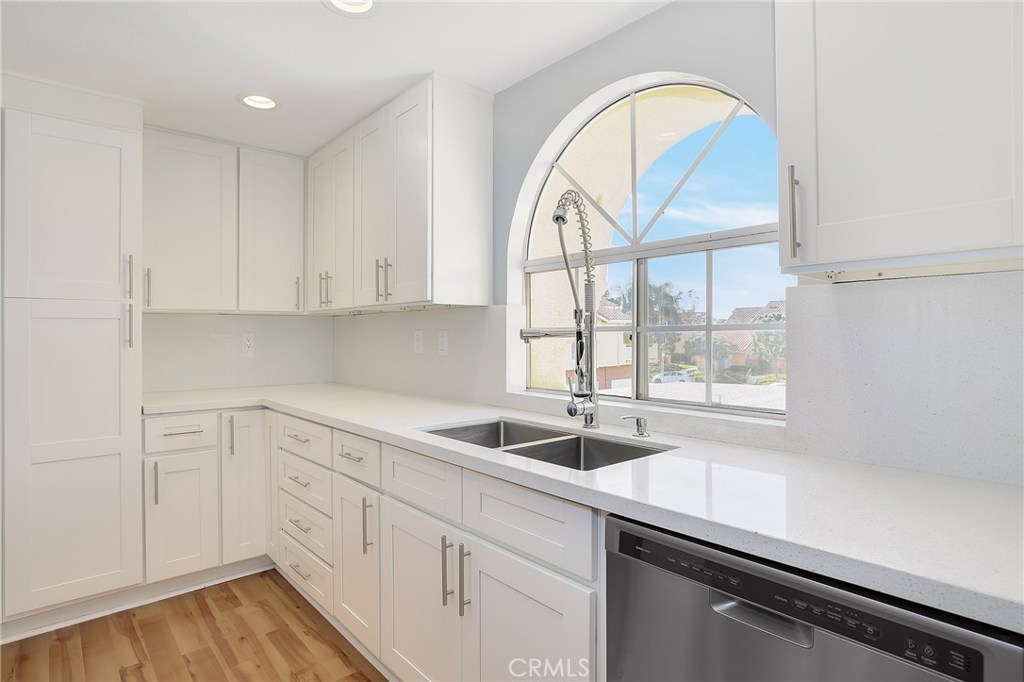 Completely remodeled, this upstairs end-unit condo in the Westpark Tiempo community of Irvine is move-in ready. Rich wood laminate floors throughout, custom baseboards and door trims, vaulted and scraped ceilings and recessed lighting complement the bright and open floorplan. Enter into the inviting living room with a cozy gas fireplace. The living room flows to the dining room with a custom built-in work desk area with two desks which can also be used as a buffet area. The kitchen is well appointed with quartz counters and backsplash, new white shaker soft-close cabinets, stainless steel appliances and deep tub sink with custom faucet. The master bedroom features dual closets, sliding doors to the private balcony and an en-suite master bathroom with a quartz-topped vanity and roman bathtub. The secondary bedroom is generously sized and is adjacent to the full hall bathroom. Additional features include closet organizers, kohler sinks and toilets in bathrooms, an indoor laundry closet with newer washer and dryer, newer water heater, a spacious front patio, a one-car garage and an additional carport space. Enjoy the community pool and spa, nearby shopping and dining options and award-winning Irvine schools. Check out the pictures and the Virtual 3D Tour!