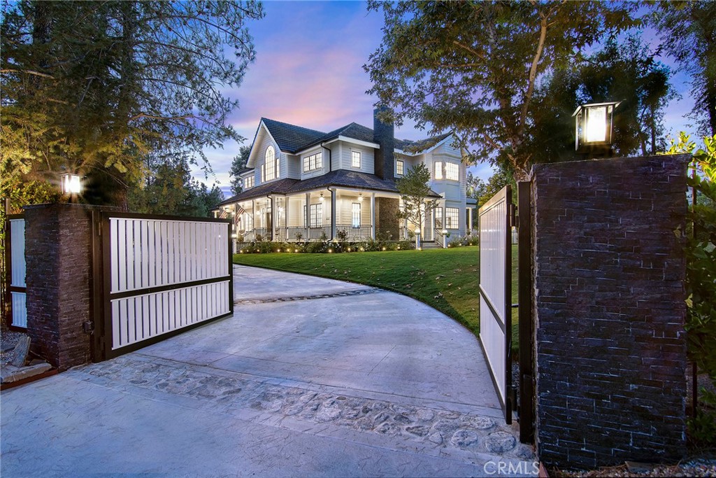 Luxury meets functionality in this private 7,122 sq ft modern industrial farmhouse designed by Sexton Farms. Nestled on 1.5 acres of flat land, this 5-bedroom, 7-bathroom estate offers modern amenities and timeless design, with potential for two ADUs.
Step inside to discover wide plank oak flooring, vaulted ceilings, and spacious hallways creating an open atmosphere. The wraparound porch, complete with swings and fans, invites you to enjoy the outdoors year-round.
At the heart of the estate is a chef’s kitchen with quartzite countertops, a Sub-Zero double-wide refrigerator, an 8-burner Blue Star stove, dual ovens, dishwashers, and an oversized walk-in pantry. The adjacent butler’s pantry with custom butcher block countertops adds storage and prep space.
The oversized primary suite is a sanctuary, with a morning kitchen, fireplace, and private balcony overlooking the grounds and mountain views. Two large walk-in closets provide ample storage, while the spa-like bathroom boasts a freestanding tub and steam shower.
For entertainment, enjoy the state-of-the-art soundproof movie theater, offering seating for 12, a 5.1 surround system, and an 86-inch screen. The custom concession center “candy bar” enhances the experience. Adjacent is a den/playroom or possible bedroom with an attached bathroom.
The entertainer’s yard is a paradise with an oversized pool, waterslide, jacuzzi, firepit, outdoor fireplace, sport court, putting green, grassy area, and outdoor kitchen with BBQ, sink, and gazebo. A large organic garden offers space for homegrown produce. The motor court provides parking for up to 8 cars.
The functional mudroom includes custom storage lockers, a bathroom, and a large laundry area with a dog shower. Dual floor laundry ensures convenience.
Enjoy breathtaking sunrises and sunsets over the Santa Monica Mountains, embodying relaxation and nature. Equipped with a Brilliant smart home system with 4 controllers accessible via a mobile app, this estate offers seamless control of home features.
This property is a rare find, combining luxury with functional design in a coveted location. Don’t miss the chance to make this exceptional home yours.