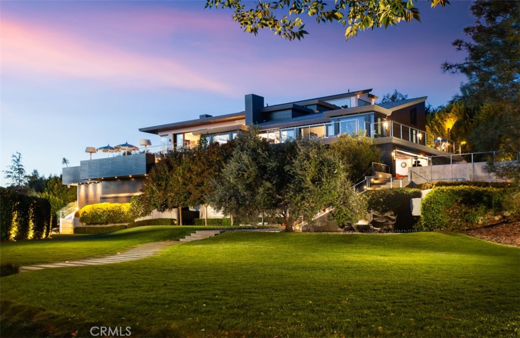 This extraordinary modern compound features the finest high-end amenities complete with world-class designer fixtures and is leagues above the rest. Situated on a secluded, very rare over an acre lot in the beautiful Cameo Highlands, this opulent home combines ultra-contemporary design & breathtaking, panoramic ocean views. The meticulously-maintained grounds include a stunning pool & spa accented by Ann Sachs tiling, sauna, a 25,000 gallon koi pond & poolside cabana with an outdoor barbecue, full kitchen & sub-zero fridge. Attentive details & exquisite taste throughout exude a sense of modern luxury, from the Baccarat chandelier in the entry to the Italian lava rock stone flooring & floor-to-ceiling glass windows. Entertain effortlessly with a 9-TV theater, underground disco, & 69 hidden subwoofers in just the living room, with disco balls that retract back into the ceiling, all made more user-friendly by the creston smart system. Framed by beautiful Pacific Ocean & Catalina views, the German Bulthaup kitchen features marble counters, custom cabinetry, a built-in Miele coffee system, Gaggenau oven, stovetop & steamer. A massive rooftop deck, private gym, elevator, & custom wine room with double racks & wet bar complete this elegant estate. There is also approved plans for a subterranean garage that would be every car collectors dream. A world-class neighborhood, Cameo Highlands, offers direct access to the beach, close proximity to 5 star dining, & amazing shopping.