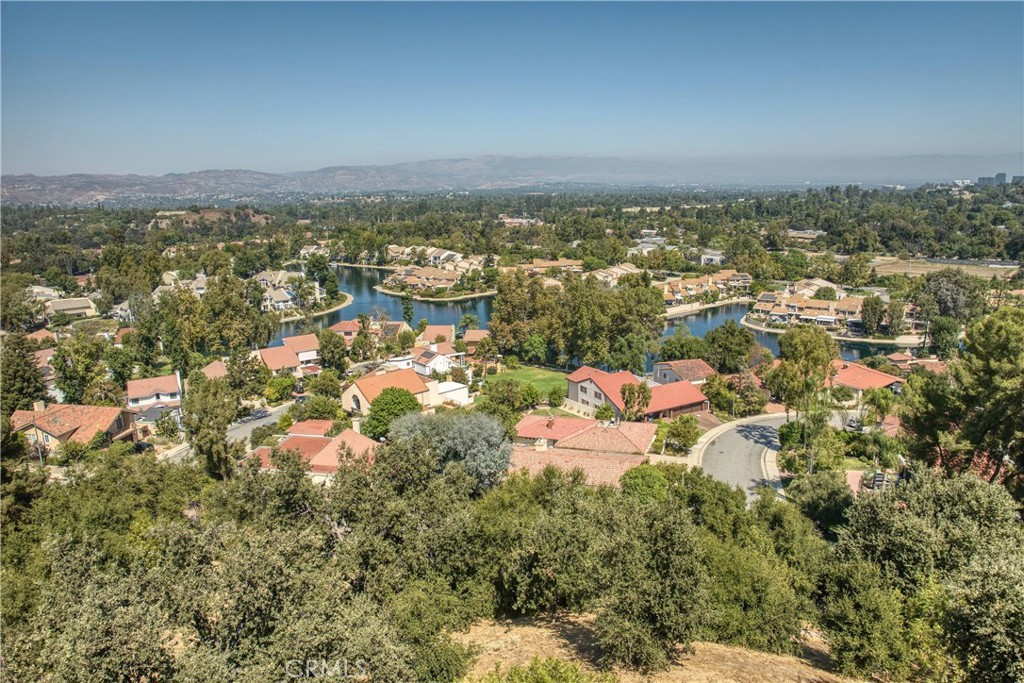 Welcome to a home that feels like a vacation you never want to leave. Nestled at the end of a tranquil cul-de-sac, this stunning 3,875-square-foot retreat offers jaw-dropping views of Calabasas Lake and the sparkling cityscape beyond. But the views are just the beginning. Step inside, and you’ll immediately feel the light and space around you. The primary suite is a sanctuary of its own, with soaring ceilings, a private balcony where you can sip morning coffee overlooking the lake, and an en-suite bathroom that rivals any five-star spa — featuring a newly remodeled stand-in shower, double sinks, and not one, but three closets Oh, and there's a bonus room for your dream home office or personal gym. The main level invites you to spread out, with two oversized bedrooms, a sleek full bathroom, and the convenience of an upstairs laundry room that makes life just a little easier. At the heart of the home? A chef’s paradise. Picture yourself in the expertly updated kitchen with top-of-the-line stainless steel appliances, a Sub-Zero fridge, six-burner cooktop, and double ovens that beg for your best recipes. The open layout flows seamlessly into the family room, living room, and a versatile space that could easily be your formal dining room or cozy den, all adorned with sophisticated travertine floors. But wait — there’s more. The attached ADU, built in 2020, is a game-changer. Two bedrooms, two bathrooms, its own stylish kitchen, private laundry, and a separate entrance make it the perfect space for extended family or guests. Step outside, and the magic continues. The backyard is a blissful escape, with a spa, soaking pool, and a calming waterfall that invites peace with every ripple. From sunset views over the lake to the gentle sounds of water, this is where everyday stresses simply melt away. With the park and lake just steps from your door, this property seamlessly blends luxury, comfort, and nature. Calabasas living has never looked — or felt — this good.