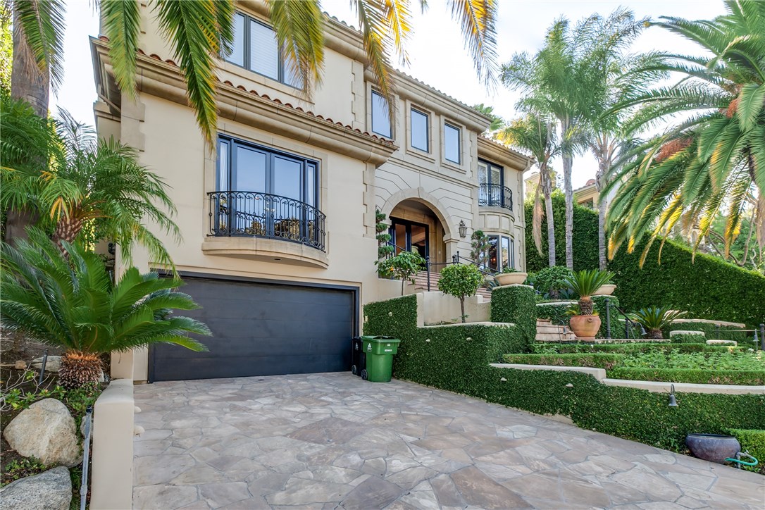 Exquisite property situated in the prestigious 24hr guarded Mulholland Estates! Nicely positioned with a commanding street presence on an expansive 22K+sqft lot, this property boasts an elegant facade w/stone steps leading to entry doors.Upon entry, you’ll experience a light & bright 2 story grand marble foyer complete w/ballroom-styled chandelier & a sweeping spiral staircase.The grand foyer is framed on both sides by a formal living room & a rich wood-paneled library,wet bar, & wood burning fireplace.The generous gourmet kitchen features Miele appliances,center island,built-in wine cooler, & breakfast nook with large windows overlooking the private landscaped backyard.The adjacent family room offers an inviting space to congregate around a large fireplace surrounded by custom wood paneled walls & built-in shelves.Upstairs the master suite opens to a large balcony overlooking the beautiful backyard & pool, along with two separate luxurious spa bath. In addition to the generous master, there are 4 bedroom suites upstairs with walk in closets. Accessed via elevator or stairs, the basement features 2 additional bedroom suites, a large media/theater room 6 car garage.The tranquil backyard includes a refreshing pool, spa, BBQ cooking station with granite counter topped bar, an entertainment pavilion with fireplace, misting, heating, & surround sound system throughout. This is all-encompassing dream home is perfect for anyone looking to experience a unique & luxurious life style.