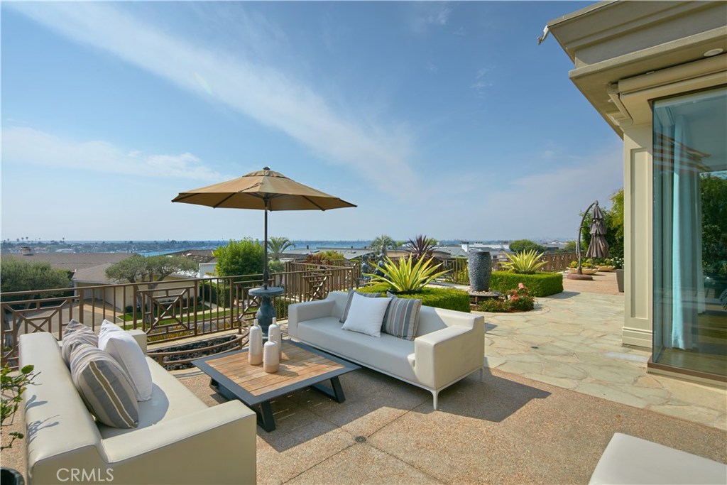 Situated on an oversized corner lot within the exclusive coastal enclave of Irvine Terrace is this exceptionally crafted and maintained single-level estate where open-concept living is infused with breathtaking panoramic views. Resting on a 15,000+ SF parcel, the site delivers a choice selection of sun-lit exterior living including a lushly landscaped and gated courtyard with pool/spa and fireplace protected from the elements, and an expansive backyard patio host to casual seating and dining areas, a gas fire pit and built-in BBQ with a backdrop of ocean, Catalina, harbor and sunset views. Inside the home, a blend of rich natural stone, woods, and woven materials punctuated by flawless hand-crafted millwork produce an effortless elegance, like that of the highest caliber five-star resorts. Each common area flows into the next with a gourmet kitchen at the heart, where double Sub-Zero refrigerator/freezers, a huge center island with marble countertops and wine cellar sustain entertaining of any scale. Measuring nearly 4,200 SF, the spacious home encompasses 4 bedrooms & 4.5 bathrooms including the primary suite featuring ocean views that extend into an oversized walk-in closet complete with custom organization system, island and direct courtyard access. Whole-house water filtration, solar panels, built-in audio, and motorized shades are additional highlights of this exquisite residence set on a single-loaded street in arguably Corona del Mar’s most sought-after community.