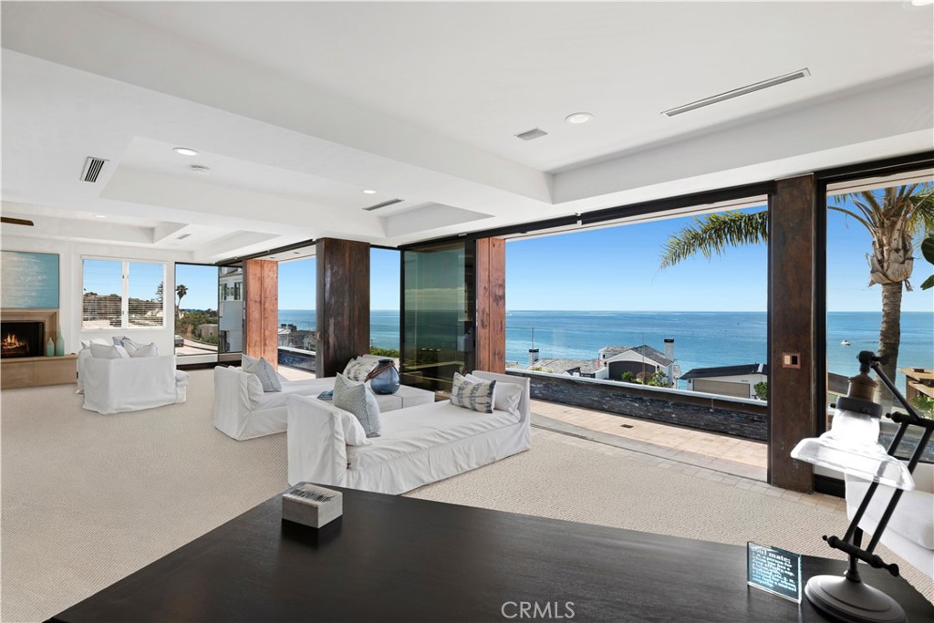 Appreciate breathtaking whitewater ocean, Catalina Island, and Big Corona beach views in the heart of Corona del Mar. Situated on an elevated lot, this soft contemporary estate has approximately 7,581 square feet of open-concept living space. The furnished masterpiece has four bedrooms and seven baths in the main residence, a subterranean temperature-controlled wine cellar, gym, billiard/game room, and an elevator (servicing all three levels) to the 360-degree view rooftop deck with a jacuzzi. Upon entry to the property, you have an inviting entertainer’s terrace with fire feature, that spans the width of the home and offers views of the stunning southern California coast. Walls of glass glide away for indoor/outdoor beach living at its finest. In addition, the exceptionally large second-level master suite occupies the width of the property and presents endless ocean views, a spa-like master bath retreat, wood burning fireplace, a sitting area + office area, an attached gym, and a closet + dressing room. The gallery hall boasts soaring ceilings allowing for natural light throughout the residence. All the benefits of a gourmet kitchen you would expect are present including a butler pantry with a Sub-Zero refrigerator, an oversized LED-lit island, and a view. The home also includes three wood-burning fireplaces, a four-car garage, and a detached full one-bedroom Accessory Dwelling Unit with private laundry. The sophisticated ocean view property is ideal for the most discerning clientele.