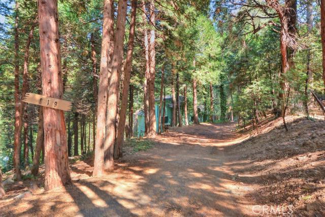 This One Of A Kind Cabin is tucked into the trees with view of mountain peaks. You will enjoy Privacy and a feeling of Seclusion but still just a short walk from Toptown shops and cafes. Easy commuter access with off street parking for 4 or more cars. Open the front door to unique Rustic Lodge Style - Up the open staircase that overlooks living room to 1/2 Bath And Two Cozy Bedrooms. The dining area opens to Vaulted Ceiling living room with Hand Hewn Logs, Wood Floors and Appears to be original Split Granite Rock Fireplace. Other main floor features are a charming kitchen, full bath, and added pantry room with a view, laundry, and desk/counter space. The covered back deck is great for entertaining and leads to back yard and walkway to lower level - Bonus room - could be 3rd bedroom, office space, or game room - with 3/4 bath and additional laundry hookups. Come see this desirable Crestline Cabin and you won't want to leave. Seller bought another home and is motivated!