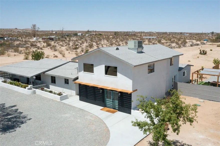 Prepare to be amazed by this extraordinary creation! Expertly designed and meticulously crafted, this unique Joshua Tree retreat is situated in a dream desert location. Nestled on nearly 5 acres land, fully fenced acres, this stunning estate offers breathtaking desert views and sunsets. It features 4 bedrooms, 5 bathrooms, and an oversized media room, plus a separate detached guest or creative space.



As you enter the main living area, you are greeted by soaring ceilings and top-of-the-line, custom-crafted designs and accents in every direction. The phenomenal layout maximizes privacy while creating an entertainer's paradise. The home comes fully furnished with designer-selected new and vintage pieces included in the sale, exuding Joshua Tree's artistic and quirky culture throughout.



The primary suite occupies the entire upper level, featuring a lavish penthouse-like ensuite, walk-in closet, and romantic desert views. Each bedroom has its own custom-designed ensuite bathroom. The grand open-concept kitchen is a chef's dream, with handcrafted doors, a live-edge wood custom-built island, and direct access to multiple lounge areas, including a covered dining area with built-in water misters and bar seating.



The outdoor space is a true playground for all ages. Enjoy a refreshing dip in the oversized outdoor cowboy pool, entertain friends at the horseshoe ring, or host an unforgettable gathering in the resort-like private setting. The separate retreat is perfect for guests, parties, or creative endeavors such as a future recording studio, artist retreat, or in-law quarters. The sleek U-shaped driveway offers ample parking, including an EV charger.



Conveniently located on a paved road near downtown Joshua Tree, Joshua Tree National Park, and nearby art and music festivals, this property is ideal for those seeking a profitable vacation rental investment or a dream desert home. This rare gem is sure to impress!