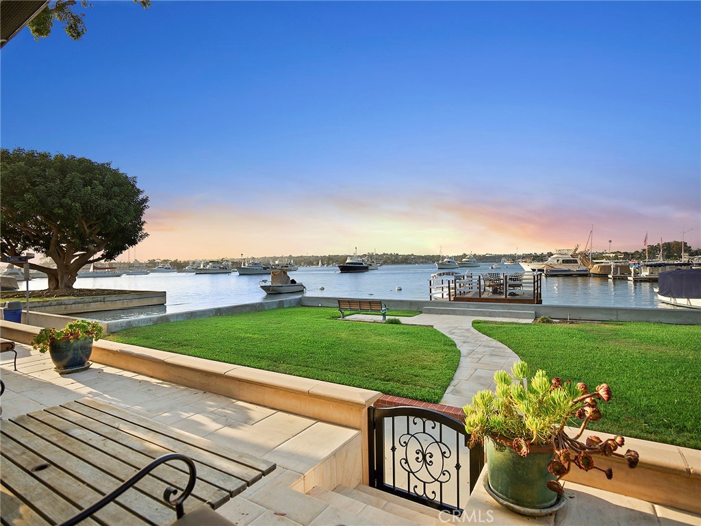 Presenting 507 W. Edgewater: a stunning custom-built 5 bedroom, 4 ½ bath estate with expansive, unobstructed main channel & turning basin views in one of Orange County’s most prime & sought-after locations. Situated on a rare, corner lot, this elegant yet current design effortlessly exudes the southern California lifestyle of seamless indoor/outdoor living. At nearly 3,900 square feet, the light-filled property boasts attention to detail, creating a striking canvas for the finest materials and finishes. The exterior is beautifully detailed with smooth hand-colored & applied stucco, stone masonry highlights & slate roof reminiscent of a French style chateau. With 50 feet of bay frontage, recently redone seawall & private dock designed for a 63' vessel & a side tie, grassy area & a roomy patio for alfresco dining, this home was created for year-round entertaining. Handsome limestone & hardwood flooring flow throughout the open floor plan & accentuate the numerous highlights, including a gorgeous staircase with wrought iron design, stone-clad fireplace, custom wood built-ins in the living room, state of the art chef’s kitchen with professional-grade appliances, custom wood cabinetry & stone counters, & a generous master suite featuring panoramic harbor & water views. Large guest rooms, upstairs laundry room, whole-house surround sound, 2-car garage, & close proximity to world class shopping, dining & pristine beaches make this property the ultimate coastal waterfront retreat.