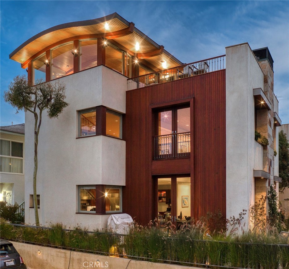 When one endeavors to build a special custom home it starts with an excellent location. 401 27th Street, MB fits the bill, sitting on the crest of 27th St and Alma on an oversized, north corner. This special plot allowed the family to assemble a dream team to design and meticulously build their iconic home, reverently referred to as "Cloudbreak". Combining exceptional design talent (Jon Starr), with precision, quality building (Dan Bronner) and no budget restrictions, they were able to create incredibly special living spaces that allow privacy, tranquility and massive ocean views. Cloudbreak is a coastal oasis with an unheard of 6,227sf of open living space above ground, including 4 bedrooms and a kids family room that could easily be a 5th bedroom. Upon entering through the mahogany outer gate, one steps into a stone courtyard sanctuary, centered around a majestic 25' tall Laurel tree that welcomes you to the heart and soul of the home. The ground level open entry is designed with massive 9’ floor to ceiling wood sliding pocket doors that open into seamless indoor/outdoor living spaces. Also, rare, is the brilliant layout placing the main living areas on the ground level. A unique feature that benefits from having ocean views from all levels. From its dramatic great room with its 20’ Douglas Fir ceilings, well-appointed gourmet kitchen, expansive island, dining area, 6 zoned AC and second family room with an elevated ocean view stone patio to the west, perfect for entertaining with its fire pit or BBQs. The second floor has rich built-in library shelves, cabinets, a fireplace, enough room for a billiard table and a beautiful office with sliding mahogany & glass doors. The east area of the second floor, one finds 3 large bedrooms, two baths & a spacious kids family room that could very easily be converted into a fifth bedroom suite. The top floor offers a world-class ocean view living area and a bar purposely designed for entertaining that flows seamlessly to the spacious indoor/outdoor entertaining haven with a fireplace, spa tub, BBQ and seating area with unblock-able ocean views from Palos Verdes, past Catalina Island all the way to Malibu and beyond. Going east on the top floor, one finds the luxurious, private primary suite, which is a virtual paradise with a custom stone, tiled spa-like primary bathroom, walk-in closet & a 400sf stone deck along its southern flank. This timeless masterpiece awaits you. Shown by appointment only. www.Cloudbreakmb.com