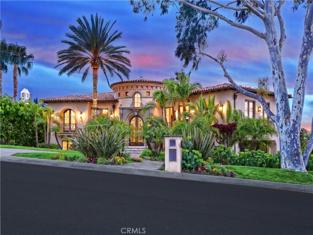 Meandering the winding roads of Palos Verdes Estates, your eye catches the elegant Louis Tomaro-inspired Mediterranean estate that stands out from all the rest. The stunning tropical landscape reveals an imposing rotunda atop a 10-foot wrought-iron and glass entry door flanked by wrought-iron balconies. This 8,750 SF multigenerational home graces a 30,000+ SF site featuring a resort-like backyard complete with tennis & basketball court, beautiful pool & spa, outdoor kitchen & bar, English garden centered around a built-in fire pit & stone topped benches, ALL with sweeping views of the ocean, Catalina Island and Palos Verdes canyons. What awaits you is an expansive, coastal-contemporary home that flows from room to room, showcasing beautiful details at every turn. As you enter, look up to the 24-foot high dome with a hand-painted sky mural. Look past six stately columns into an open and wide upstairs space with the Library, Family Room, Living Room and Formal Dining Room all in view. Just up the steps you are greeted with panoramic ocean views that draw you in to the Family Room which is open to the huge updated Chef’s kitchen featuring 2 islands, 2 sinks, 3 refrigerators and high-end appliances. Also in this space is a beautiful architecturally designed round breakfast nook with 7 extended half-round windows framing the beautiful ocean views. Over 300 SF of covered deck wraps around this space, lending itself to unparalleled ocean viewing. Complementing the large living spaces upstairs are 3 bedrooms including the Grand Master Suite. Before entering this grand room you encounter a first set of double doors that opens to a sitting room or office with impressive ocean views. Enter through a second set of doors to the master suite complete with a fireplace and French doors opening to a private balcony overlooking your resort estate and stunning ocean views. The En-suite Master Bath has a private wash closet, vanity, his & hers sinks, large soaking tub, extra wide steam shower and a huge dressing room/closet. The equally impressive lower level is accessed by your choice of the left or right curved staircase OR from the full size elevator. Here you will find a 2nd Grand Master En-Suite, 2nd kitchen, complementary bedrooms & bathrooms, family room, media room, office, 3 fireplaces, and a 200-bottle wine room. Proceed outside to enjoy your resort and unobstructed ocean views. Don’t miss your chance to own this unique generational estate!