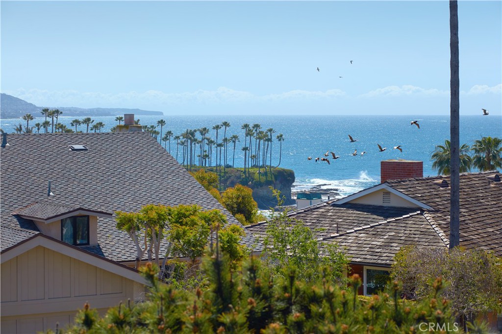 Tranquility AND Proximity... Just steps from the sand and Crescent Bay Park in north Laguna Beach, this meticulously rebuilt and remodeled home boasts serene panoramic ocean views from both levels. Offering a modern, upscale beach house vibe, the open and bright residence captures gorgeous whitewater vistas of the Pacific Ocean, Dana Point Headlands and evening lights. A retreat of tranquility and privacy, the Mid Century design was originally designed by Herb Brownell, and reimagined by Gallo Builders and top local interior designer Michael Fullen. Appx. 3,722 SF, the impressively sized home elevates curb appeal with beautifully maintained landscaping, a 3-car garage with individual glass roll-up doors, ample driveway parking, and a gated entry patio that is quiet, serene and welcoming. Lightly enjoyed by its current owners as a vacation home and never rented, the residence features nearly 2,000 SF across three outdoor living areas. Indoors, the fireplace-warmed living room and adjacent dining room open via a 25' Fleetwood sliding-glass door to an ocean-view 40'-wide deck. A massive island with seating is topped with a single slab of Carrara marble in a chef-inspired kitchen that hosts Caesarstone countertops, gray Shaker cabinetry, a solid Carrara marble farmhouse sink and a pantry. Thermador appliances include a 6-burner cooktop with griddle, cabinet-matched built-in refrigerator, and a full-height 80-bottle wine refrigerator. Enjoy open-beam vaulted ceilings, skylights, oak flooring, commercial-grade fire sprinklers throughout, and custom closet systems in all bedrooms. Five bedrooms and four-and-one-half baths include a top-level ocean-view primary suite with deck access, walk-in closet and lux bath. One bedroom makes a great office on the upper floor, and one en-suite bedroom opens to the lower level’s ocean-view patio and fire pit. A bonus/media room with fireplace opens to the backyard and is adjacent to a versatile gym and a large laundry room with sink and cabinetry.