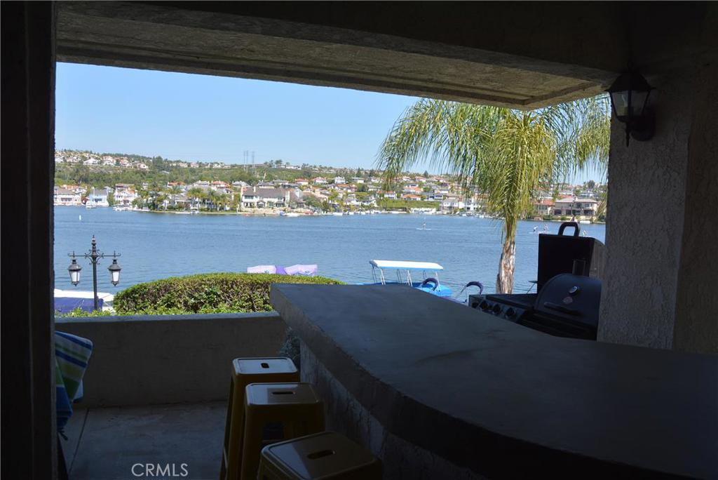 It is important to note that these photos of the views of the lake are all taken from the actual residence itself. This is lake front living at its finest... Garden level location is both quiet and private. Landlord is in the process of installing new stone flooring at a cost of $20,000. HOA amenities include private beaches, 2 pools, 2 spas, boat docks, fishing dock and 24/7 manned gate. Light and bright interior. You feel like you are surrounded by water as mirrors in Living Room allow lake to be seen in every direction. Large rear patio is perfect for dining, entertaining, relaxing or just watching the events on the lake float by. 2 beds, 2 baths, 2 car garage. Near shopping and dining at Plaza on the Lake. Lake membership is included.