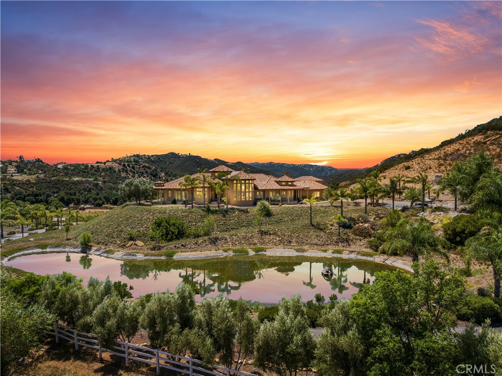 This nearly 40-acre equestrian estate is the ultimate luxury retreat for horse enthusiasts, offering breathtaking panoramic views, unmatched privacy, a pool, spa, and miles of scenic riding trails. Designed for both relaxation and entertainment, the property boasts exceptional architectural details and top-tier amenities, including two wells, solar power, and RV parking with hookups—all with NO HOA!
Bordering the National Forest, the estate features a stunning 4,486 sq. ft. main residence with three bedrooms, a den, and 4.5 bathrooms, alongside a separate 1,064 sq. ft. guest house with two bedrooms and 1.5 bathrooms. The impressive nine-stall horse stable connects to expansive, securely fenced areas where horses can roam freely. From this property, you can ride all the way to the Pacific Ocean!
A grand gated entrance leads to the main house, passing a picturesque pond complete with a fountain, two aerators, underwater fish housing, and a charming duck house. There’s ample space to add a horse arena, private vineyard, or even motocross tracks. The slab area behind the stable is perfectly equipped for RV parking with electricity and water hookups.
Designed for effortless entertaining, the elegant chef’s kitchen features an eight-burner stovetop, a wet bar with a wine refrigerator, a butler’s pantry, and a full outdoor kitchen. Guests can gather in the formal dining room or the casual dining area adjacent to the main kitchen, each with its own fireplace. Outside, a fire pit sits next to the pool, which includes a fast lane feature for swimming workouts. The spacious laundry room and butler’s pantry offer abundant storage and a large island.
The guest house, built in 2015, includes a separate laundry room, its own septic system, and a walk-in tub—perfect for multi-generational living, with potential for expansion. A thoughtfully designed covered breezeway connects the garage to the main house, featuring a Dutch door and a full bathroom with a shower, making it ideal for pets.
Experience unparalleled indoor-outdoor living, stunning natural surroundings, and world-class equestrian facilities at this one-of-a-kind dream estate!