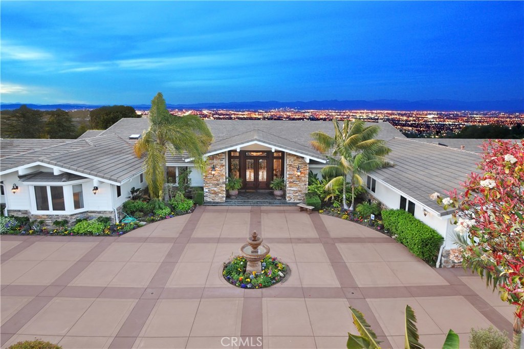 Behind the gated entry lies a 4.5 acre, luxury oasis, perfectly situated overlooking stunning panoramic views. Created by the renowned, Tony Ashai, this estate is a masterpiece of design and craftsmanship featuring 5 bedrooms + den, an office, 7.5 bathrooms, over 9,600 sq. ft. in the main house, and 6-garage spaces. The grand entrance exudes opulence, as you enter the formal living room you are greeted by expansive views. The easy flow of the floorplan allows the spacious main level to feel comfortable and livable. Enjoy entertaining in the large custom kitchen and formal dining room. The west wing of the home leads to the main bedrooms, all boasting en-suite bathrooms and walk-in closets. Three of the bedrooms enter off of a private den which is perfect for children to make their own. The master bedroom is the ultimate retreat, complete with a spa like bathroom, walk-in closet, and a fireplace with seating area. The spacious lower level is great for entertaining with a game room, movie theater, sauna, and den. Enjoy the beautiful backyard oasis including an outdoor kitchen, huge deck as well as a pool and spa all overlooking a sprawling lawn with unobstructed views of the city, mountains, downtown, queens necklace and ocean! The 2 bedroom, 1 bathroom, 1400 sq. ft. guest house has a kitchen, living room, private driveway and 2-car garage. The possibilities are endless with room for a riding ring, barn or tennis court, sports court and more. This property truly has it all!