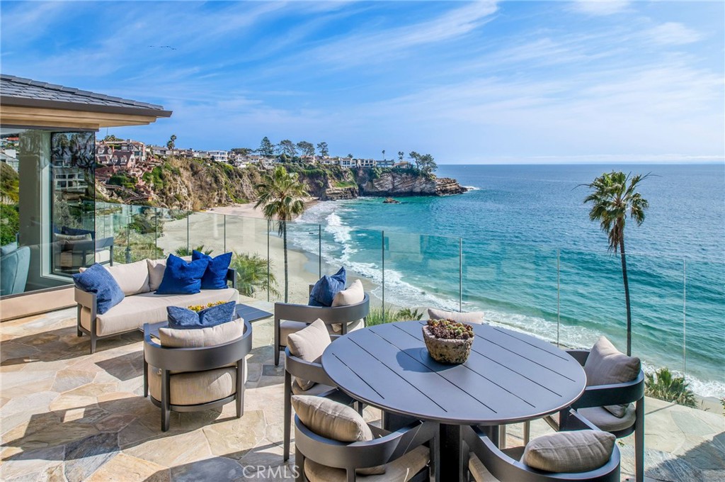 Experience the allure of South Laguna’s coveted Three Arch Bay in this newly furnished contemporary bluff front home. A private, guard-gated
community offers exclusive access to a private beach and community amenities. Designed by Brion Jeanette and completely rebuilt in 2013, this
estate underwent a refreshing update in 2022. The well-thought-out floor plan includes a main-level master suite plus 4 bedrooms and a bonus
room. Drive up the long driveway to find ample parking and a three-car garage with an elevator leading to the first level. The private gated entry
welcomes you to an entertaining courtyard boasting a waterfall spa, fire pit, and outdoor kitchen with a built-in BBQ and teppanyaki grill. A guest
casita with a separate entry and a fully equipped home office enhance the property’s versatility. Glass double doors lead to the main level,
showcasing expansive floor-to-ceiling Pacific Ocean views. Revel in the master suite with new hardwood floors, a walk-in closet, and a marble master bath with a steam shower. The main level also features a guest bath, a fully equipped kitchen with state-of-the-art appliances, a dining
room, and a living room with a built-in bar. Bi-fold glass doors open onto the oversized deck, creating a seamless indoor/outdoor living space
where you can watch dolphins, enjoy sunsets, or keep an eye on the kids playing below on the private beach. Descending to the lower level reveals
two more ensuite bedrooms with ocean views, a bonus room, laundry, guest bath, and an entertainment/media area with a kitchenette/bar. This
level opens onto the generous lower rear lawn with a fire pit, built-in seating, and electronic sunshades. Beach access is just steps away. The
property is offered fully furnished with brand-new furnishings and a refreshed interior, making it the ideal home you’ve been anticipating.