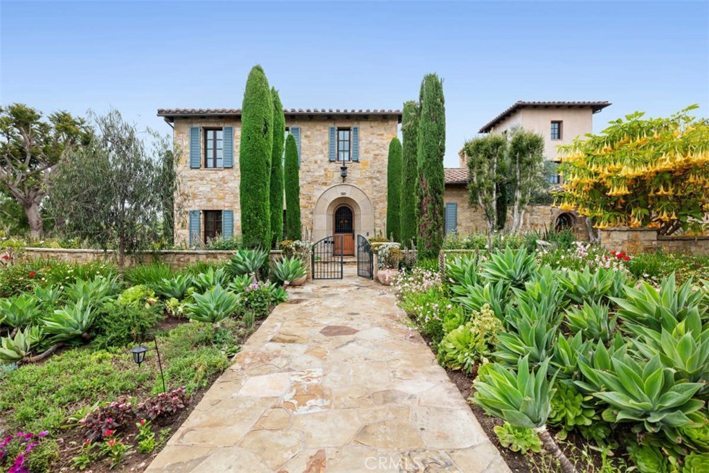 A majestic Tuscan idyll set on an extraordinary corner plot where breathtaking vistas and private seclusion go hand in hand. Situated in the renowned enclave of guard gated Shady Canyon and constructed with a discerning eye. Melding traditional formal spaces - as the home unfolds with a warm and inviting office adjacent to the formal living room and an elegant formal dining room with French doors that showcase the private and open expanse that this corner lot affords. Many features of the home lend to everyday modern living - an open concept kitchen and oversized family room enriched with beamed and vaulted ceilings, stone finishes and stone and hardwood plank flooring. French doors showcase the rear yard with its refreshing pool, cabana, and several sitting areas that invite open-air entertaining or peaceful moments and where views fully capture the organic beauty of the rolling hills and golf course beyond. The 5 bedroom, 6-and-two-half bath residence offers a luxurious master suite with dedicated staircase and an awe-inspiring view terrace and spa bath, a private second level guest wing - also accessed by its own private stairwell; a main level secondary bedroom wing with three en suite bedrooms, and a subterranean level that does not disappoint with movie theater, full bath and wine cellar- large enough for a wine tasting soirée within to truly impress your guests. This special home whole-heartedly achieves an exquisite interpretation of old-world European architecture via the renowned Shady Canyon community, with its world-class amenities including swimming, pickle ball, tennis, golf, playground, clubhouse, hiking and biking trails, and 24/7 guard-gate access leaving you feeling inspired and invigorated.