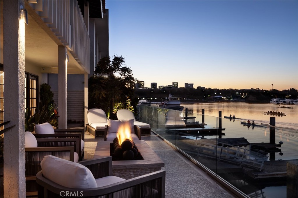 Revel in the beauty of a rising sun over sparkling waters from what is often regarded as one of the most desirable completely remodeled south-facing bayfront homes in all of Newport Beach. Enviably located on a quiet cul-de-sac street in the coveted enclave of Dover Shores, this unparalleled turnkey waterfront residence welcomes spectacular vistas of the azure horizon, glittering city lights and the shimmering bay. With appx. 60' of breathtaking frontage, the luxurious reimagined retreat includes a private dock with 3 slips that can accommodate a yacht up 60', a Duffy boat and a side tie. Sun-bathed interiors of appx. 3,912 SF are introduced by a gated courtyard featuring a contemporary fountain, lush landscaping and new decking, making it one of the most inviting outdoor living areas in the region. A step through the newer custom stained-glass entry door reveals a towering foyer, floor-to-ceiling windows, and a dramatic floating staircase that curves upwards to the versatile second-floor loft. Enjoy casual and grand-scale gatherings that guests will remember for a lifetime in open-plan reception areas that offer a new oversized temperature-controlled wine wall, a fabulously upgraded fireplace, and seamless access to the courtyard and bayside terrace beyond. Equally alluring is the newly designed chef's kitchen, where a wet bar, built-in seating, stone-topped countertops, and newer high-end Big Chill appliances combine to create the ultimate culinary experience. The main level is further distinguished by a gracious en suite bedroom and a remodeled half-bath, making guest feel as though they are vacationing at an exclusive resort. Three bedrooms upstairs include a glamorous oversized owner's suite that hosts a bay-view balcony, a sitting area, generous dual walk-in closets, and spa-like bath with a backlit walk-in shower. Completing the property is a substantial laundry room equipped with an abundance of storage, a two-car tiled garage, and an array of fine finishes and artful appointments that have been specially curated to make this home one of Newport’s most envied. Among them are custom oiled oak flooring, fully remodeled baths, textured wall coverings, new patterned carpet, new interior and exterior paint, designer light fixtures, bespoke penny-round cork accents, and crown molding. Minutes from the Back Bay, Fashion Island, and access to 3 private beaches, 333 Morning Star allows for an ultra-luxe coastal lifestyle that is second to none.