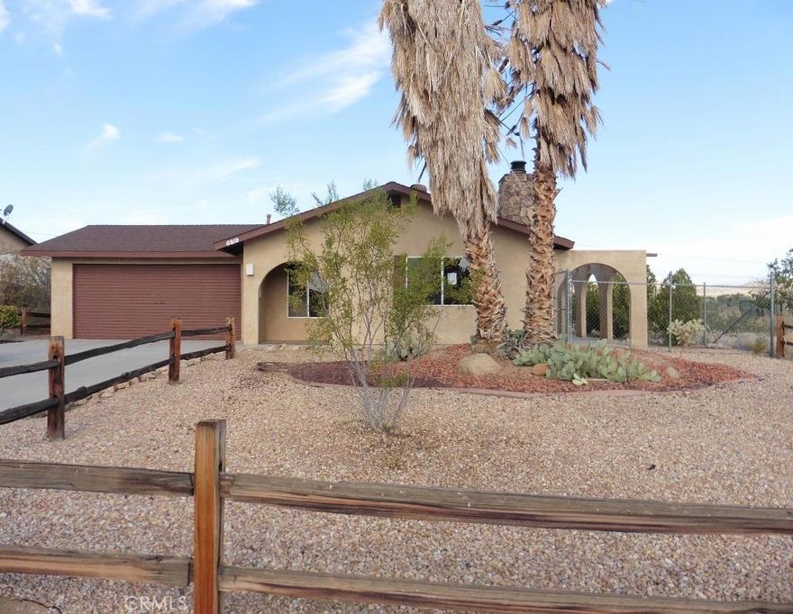 Joshua Tree Village - home with 2 bedrooms, 2 bathrooms and a den. New paint and carpet!  Great location! Living room has a lovely fireplace and sliders to a nice covered patio.The kitchen is open to living room and there is a dining area too. The den is just off the living room and has a 3/4 bathroom. Two spacious bedrooms, one with full bath and sliders to a small covered patio and woodfenced courtyard. The backyard is chainlink fenced and has great westerly views. Two car garage as well. Natural gas. Convenient for village shopping.