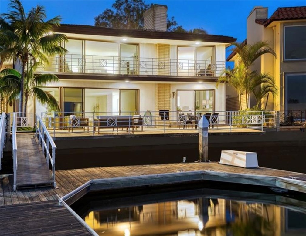 Located on exclusive and guard-gated Linda Isle, this bay front home rests on one of the island’s largest and best-located parcels. Sited at the foot of the private lagoon, the home features panoramic water views. Exquisitely designed by the renowned architect J. Lamont Langworthy and completed in the fall of 1969, this pristine mid-century design has been impeccably kept for decades. The spacious residence of 5,655 square feet is light, modern and timeless. Walls of glass carefully frame the water views, while carefully placed rooms throughout the plan are bathed in diffuse afternoon sun. Formal and informal areas are generously proportioned and include a waterside living room opening to the bayside terrace, a large formal dining room, and a dramatic two-story great room + serving bar. Through a west-facing two-story wall of glass, this amazing entertaining space opens to a private tropical garden and courtyard. The three-room master suite spans the width of the home on the water and takes in restful water vistas. The secondary bedrooms are spacious and light. Included with the property is a private use dock. Few parcels and homes on Newport Harbor are as large, gracious and accommodating as this fine representation of period California architecture.