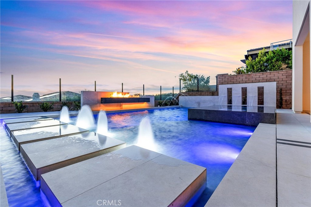 Welcome to the epitome of luxury living in the serene Orchard Hills community of Irvine. This remarkable 5-bedroom, 5.5-bathroom home redefines elegance and comfort, establishing a new standard for sophisticated living. Enjoy harmony both inside and outside this residence.
Upon arrival, a grand foyer welcomes you with a striking curved staircase, ascending through a captivating double-volume space, complemented by a well-appointed second level. Nestled in the Orchard Hills, you can savor sunset views from the comfort of your home. This exquisite residence (Around 1 million in Upgrades and Landscaping including swimming pool) features an open and elegant floor plan, ideal for entertaining and family living. The gourmet kitchen is a chef's delight, equipped with top-of-the-line appliances, luxurious countertops, and a spacious island, making it the heart of the home. Abundant natural light bathes the generous living spaces, creating a warm and inviting ambiance.
The main floor offers a relaxed great room, a formal dining room, and an office area designed to meet your individual needs. Sliding glass doors seamlessly connect the indoor and backyard spaces, providing a stylish relaxation area.
The tastefully designed primary bedroom features an oversized walk-in closet and a luxurious spacious bath with a free-standing soaking tub and a captivating glass-enclosed shower, offering spa-like amenities for a serene escape after a long day. Additional highlights include a spacious upper-level bonus room, a well-appointed office, a downstairs laundry room, and generous secondary bedrooms, with two of the three featuring ensuite bathrooms. Each bedroom serves as a private sanctuary, beautifully appointed.
The outdoor living space is perfect for enjoying California's year-round perfect weather. The custom outdoor kitchen, built-in seating area, and infinity pool perfectly complement the world-class views this home offers. The Orchard Hills community offers resort-style amenities, including pools, parks, and hiking trails. With top-rated schools, shopping, and dining just minutes away, this is more than a home; it's a lifestyle. Don't miss the opportunity to make this exceptional property your own and experience the ultimate in Southern California living!