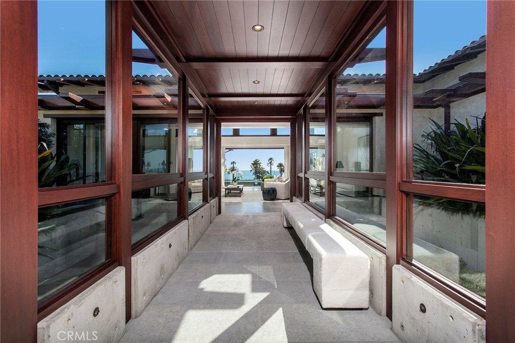 A once in a lifetime opportunity to enjoy 5-star resort amenities in the privacy of your own custom estate. This unparalleled property is situated in the exclusive enclave of the Montage Resort. Steps away from the beach, architecturally stunning expert craftsmanship put into every aspect of the design, construction and landscaping. Contemporary concrete gives the home a modern feel, warmed with rich mahogany and stone flooring, custom walls of polished wood, artisan finishes, and bronze-encased floor-to-ceiling windows and doors. The 7,500 sq.ft residence has soaring 14 ft ceilings and an abundance of natural light, offering expansive ocean, sunset and Catalina views. Four master suites featuring walk-in closets with custom cabinetry and spa-like bathrooms, a professional grade kitchen, a butlers pantry, a gym, and an additional 3,000 sq.ft basement provides endless opportunities. Designed to provide the utmost privacy and best of Southern California’s indoor-outdoor living enjoy infinity pool and spa, outdoor kitchen, and lounge seating. Or relax in the lower courtyard with a teak deck, fire pit and two-story waterfall to a second private jacuzzi. Wired with the latest technology the estate also encompasses radiant heat flooring throughout and an elevator to all levels. Luxurious amenity options of the world-class Montage Resort include 24 hour security detail, fine dining, spa facilities, resort pool, personal concierge, housekeeping and room service at any time desired.