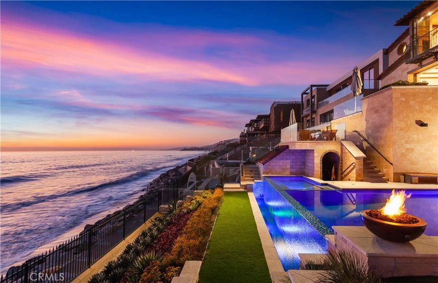 Crowning the very upper echelon of Southern California’s finest oceanfront homes, this custom tri-level masterpiece offers an extremely rare opportunity to experience life as few others can. Located on the front row of The Strand at Headlands in Dana Point, the modern Mediterranean showplace reveals breathtaking whitewater ocean views that encompass shoreline vistas, Catalina Island, dazzling sunsets and Headlands and Headlands Cove vistas. Views are enjoyed from nearly every location within the estate, which unveils Old World craftsmanship that complements today’s state-of-the-art and on-trend technology and appointments. Fold-away and hideaway walls of glass erase the border between indoor and outdoor living spaces throughout the home, and wrought-iron Juliet balconies, private patios and an entry courtyard beckon residents and guests outside. Approx. 8,823 s.f., the recently upgraded residence was built in 2018 and hosts 6 ensuite bedrooms including a separate guest villa and bunk room, 7 full and 2 half baths, a 5-car garage, 10-seat theater, and an Architectural Digest-worthy kitchen with hidden butler kitchen behind. The main-level great room opens to a view deck and shares a 2-sided fireplace with an office/library. Take the elevator to the lower level and discover an entertainment room with wine walls and a pub-style wet bar that flow to a resort backyard with infinity pool, spa, a built-in BBQ, varying seating levels, and access to the beach below