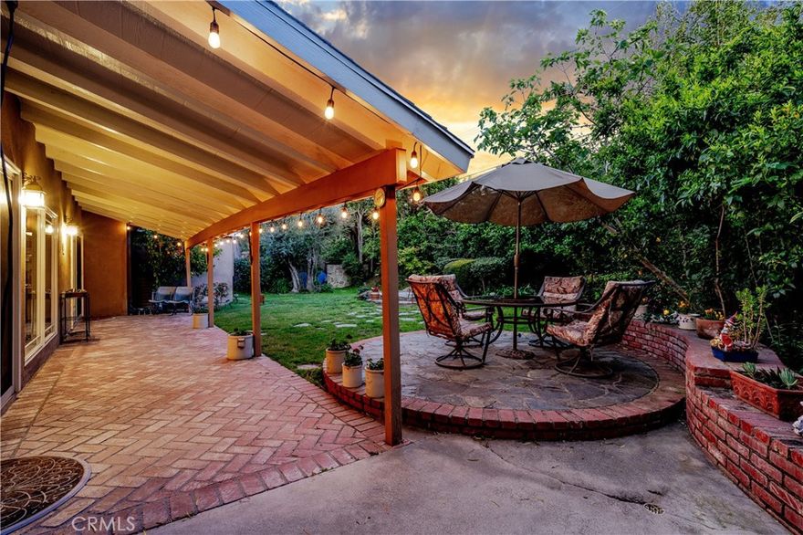 Welcome to this wonderful single story mid-century classic home showcasing 3 bedrooms & 3 custom baths nestled on a quiet tree-lined street in the much sought after area of Woodland Hills. Upon entering, the open floor plan provides spacious surroundings while the exquisite wood flooring glistens. The fabulous kitchen w/ stove-top island is ideal for entertaining, while admiring the stainless-steel appliances, granite counters, alluring wood/glass cabinetry, garden bay window, gas fireplace, ample storage w/an expansive dining area which opens to the beautiful yard. The comfortable family room features a stone wood-burning fireplace w/stunning windows. A separate dining room w/built-ins is perfect for a 4th bedroom as another door & closet are present. Down the hall are two generously-sized bedrooms, an impressive bath w/shower & hand-selected tiles. At the end of the hall rests the glorious primary bedroom w/a walk-in closet, extraordinary bath w/steam shower, heated floors, dual sinks & jacuzzi tub. Outside, enjoy the mature lush landscaping, privacy, in-ground spa, grass, sitting areas & fruit trees. Solar panels, large laundry & storage room, circular driveway and an alarm system add uniqueness. Close to award-winning El Camino Charter High School, Hale Middle School & Woodlake Elementary. Nearby is Warner Center, Westfield Village Mall & The Calabasas Commons. This is the ideal home for everyone's needs.