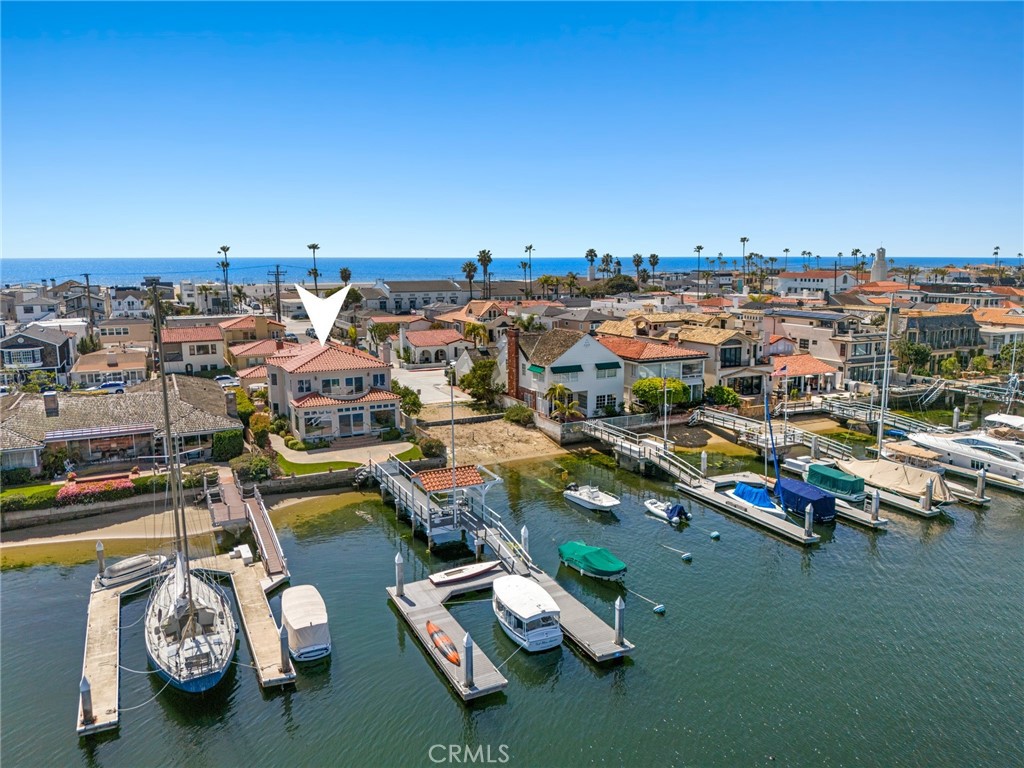 Nestled on an oversized, 48’ wide corner lot along the prestigious Balboa Peninsula, this exceptional bayfront home offers unparalleled waterfront living with breathtaking views of Newport Harbor. This highly desirable residence features a private dock and a stunning pier with a rare covered gazebo, perfect for Al fresco dining. The thoughtfully designed 3-bedroom, 4-bathroom home is bathed in natural light from skylights throughout, enhancing its airy and inviting ambiance. The luxurious master suite boasts panoramic harbor views, a private deck, a cozy seating area, and a spa-like en suite bathroom. Two additional bedrooms each have access to the back deck with a charming peek-a-boo ocean view. The beautifully appointed kitchen overlooks the bay and living room - which features a fireplace, as well as sliding doors opening out to the expansive front patio, ideal for seamless indoor-outdoor living. Completing this remarkable home is a den with a wet bar, small basement, and a spacious 3-car attached garage. Just steps to the sand and all of the activities, fine dining, and attractions Newport Beach has to offer - this is the perfect blend of elegance, comfort, and prime waterfront living.