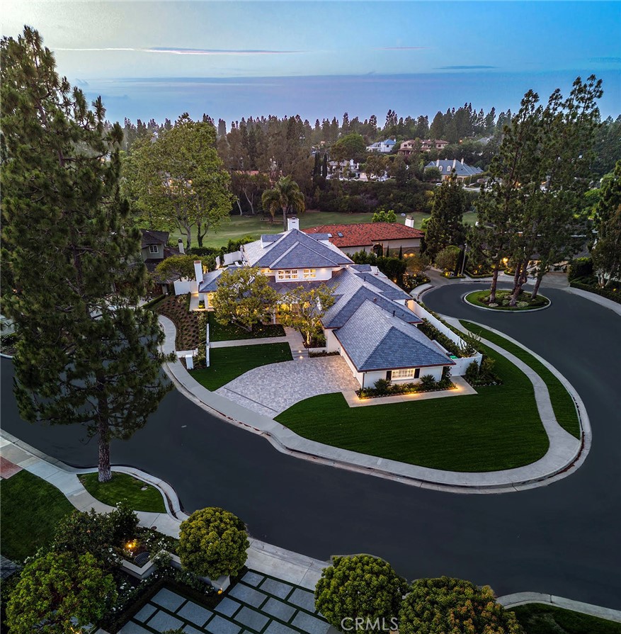 Located in the private gated country club coastal community of Big Canyon in Newport Beach, this luxurious estate boasts 5866 sqft of living space on a secluded peninsula parcel, offering unparalleled privacy and a feeling of solitude. Completely reconstructed using only the finest materials with thoughtful craftsmanship, this home is built with LEED certifications in mind. The residence features 4 bedroom suites and 4.5 bathrooms adorned with bespoke Ann Sacks tile work and premium fixtures. Communal living spaces include a theater, foyer, open great room/ dining room with La Cantina retractable doors seamlessly blending the interior with the serene outdoor spaces, media room, backyard with brand new pool and spa, Hasten BBQ area, outdoor lounge and dining space. The backyard is surrounded by new all-weather vinyl fencing and mature trees for utmost privacy. The master retreat spans the entire upper level, offering a sitting area, bedroom chamber, spa-like bathroom with Toto toilets, coffee and refreshment bar, direct elevator access, and flex space for an office, massage room, or home workout studio. The interiors are light and bright with an updated traditional aesthetic, featuring museum-grade lighting, brand new slate roof, solid white oak flooring, and premium insulation throughout. The gourmet kitchen is a chef's dream with a Dual fuel Wolf range, Subzero commercial refrigeration, walk-in butlers pantry, custom appliances including an icemaker, beverage fridge, and wine storage. Full home integration panels and touchpads control the entire house via the app-based Savant system. Additional features include 2 EV chargers in the 3 car garage and specialty designer lighting fixtures by John Pomp and Jonathan Browning. This estate offers easy access to the world-class amenities that define the Newport Beach lifestyle, from upscale boutiques and acclaimed dining establishments to pristine beaches, scenic hiking trails, renowned golf courses, and convenient airport access, providing every indulgence and convenience just moments from your doorstep.