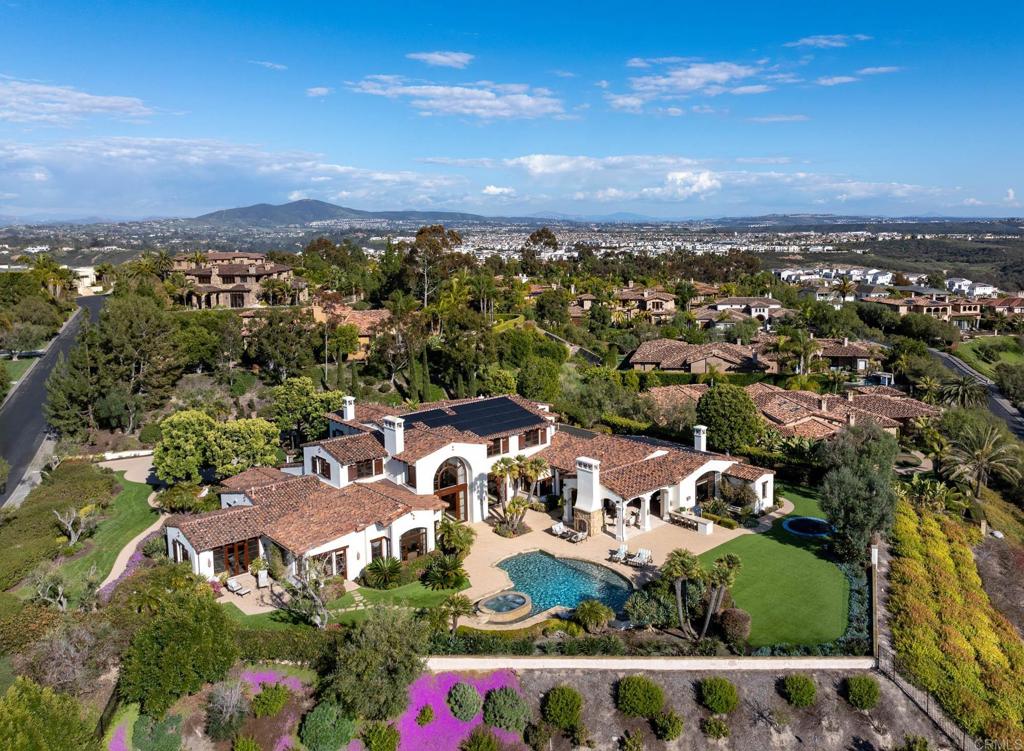 This beautifully designed and built estate, with stunning panoramic ocean and mountain views, is situated on one of the most desirable premier sites in the prestigious 24-hour guard-gated enclave of Rancho Pacifica in San Diego. Constructed in 2006, the main residence, attached guest house, and 5 car garage are nestled on 1.28 level acres and encompass approximately 11,885 sq feet. The residence is surrounded by mature lush foliage and landscaping creating a magical setting, while providing the ultimate privacy. From the moment you enter the residence through the impressive front doors, you are surrounded by high quality craftsmanship, materials, and amenities, all working together to create an inviting atmosphere of pure elegance and drama. All guests will revel in large public rooms including the living and dining rooms; a granite flanked, well-appointed, chef's kitchen with bar seating, adjoining breakfast alcove, and butler’s pantry; and grand-scale great room with fireplace, open beam ceiling and a professional bar. In addition, there is a game room, climate-controlled wine cellar, state-of-the art theatre, and wood paneled office/library. There are six impeccable bedroom suites in the main house. The first-floor primary retreat is complete with a large sitting area, stone fireplace, his and her dressing rooms, expansive and luxurious spa bath, and a gym. Other amenities include: a one bedroom, one bath attached guest house with kitchen and living room; five-car garage with an abundance of storage, built-ins, and epoxy floor; outdoor living/dining room with stone fireplace; professional grade BBQ and alfresco kitchen; sun splashed resort-style swimming pool with waterfall spa; plenty of room for lounging, sunning and relaxation; and inground trampoline. The property has been professionally decorated with custom lighting fixtures, flooring of travertine and wood, custom cabinetry, security system, whole house solar, pool solar, turf. Spectacular and so very luxurious. Rancho Pacifica is located close to the coast with some of the best southern California beaches, all major highways, great shopping, and highly ranked schools.