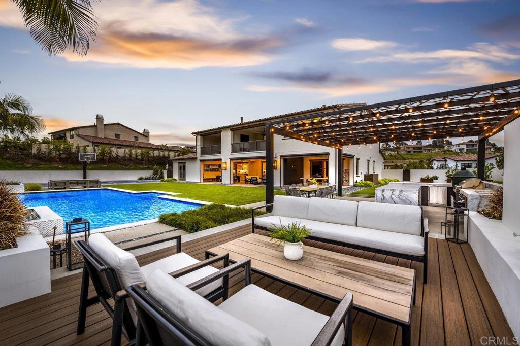Experience the pinnacle of luxury living in one of San Diego's most coveted neighborhoods. This stunning Sterling Heights Estate is nestled within the esteemed community of The Lakes, this exquisite estate offers a large view lot, lush landscaping, and resort-like amenities. First time on market, this Plan 3 home just 4 years young, boasts 5,500+ sq. ft. of living space with 5 bedrooms and 5.5 baths and a 4-car garage. Soaring 22' ceilings in the living area create a grand sense of space, while the formal dining room and chef's kitchen, with contemporary white upgraded backsplash, provide the perfect setting for entertaining. Oversized windows and a wall of retractable glass doors fill the living areas with natural light, while beautiful hardwood flooring throughout the home enhances the elegant ambiance. The Plan 3 floor plan features 1 large bedroom with en suite bath on the main floor, plus a bonus room offering endless options. Upstairs, the primary suite overlooks the resort-style pool and features a spa-like primary bathroom with dual vanities, a large soaking tub, and a huge shower. 3 additional bedrooms all with en suite bathrooms and custom-built closets. The large loft upstairs provides flexible space for a media/movie room, play area, or additional living area. And the oversize laundry room has ample storage space. The backyard is a true oasis designed for entertainment and relaxation, with a modern pool and spa, complete outdoor kitchen, sports court, and ample turf for playing. Soak in the San Diego sunsets by the custom fire feature, enjoying the views and seclusion in one of the best lots in The Lakes. This immaculate home boasts solar and a four-car garage with additional parking, providing plenty of space for family and guests. Located within the award-winning Poway Unified School District, with top-rated schools like Del Norte High, The Lakes offers a family-friendly community and an unbeatable Southern California lifestyle. Just half a mile from The Crosby Club at Rancho Santa Fe, residents can enjoy optional club memberships and world-class amenities, including golf, dining, entertainment, fitness center, tennis, pickleball, and a heated lap pool. With 25 golf courses, 17 parks, and 4 hiking reserves within 10 miles, and over 79 restaurants within 5 miles, there's no shortage of activities to enjoy. Conveniently located minutes from I-15 and CA-56 freeways, this exceptional property offers unparalleled access to all that San Diego has to offer. Don't miss your chance to own this stunning Sterling Heights estate and live the ultimate California dream.