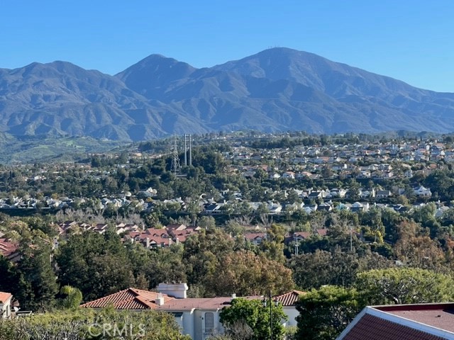 PANORAMIC/MAJESTIC MOUNTAIN VIEWS... Enjoy one of the most expansive and least obstructed views of the Saddleback Mountains in the entire city. Looking due North from your own rear and side balconies, identify and become acquainted with Mountain Peaks with names such as "Santiago", "Modjeska", "Los Pinos", "Trabuco", "Pleasants", "Hagador", "Bedford" and "Flores". Take in views of North Beach, Lake Mission Viejo, the surrounding Hills and City Lights. Participate in the Mallorca Lifestyle with its Private Beach complete with 14 picnic tables/bar-b-q's/cabana/restrooms and designated swimming area, a Manned Gate Access, 72 Boat Docks, Pools/Spas and that wonderful feeling of always being on vacation. This particular home is a 2 bedroom, 2 bathroom Baroness Penthouse floor plan with 2 balconies, a 2 car garage and no one living above or even beside you. The Kitchen has been updated with Bull-Nosed Granite Counters and Backsplash, pull-out Pantry Drawers, Stainless Steel Appliances including a 4 Burner plus Central Griddle Gas Cooktop/Hood/Kitchen Aide Dishwasher and Double Sink. Refaced Cabinets and Recessed Can Lighting round out the kitchen experience. The Guest Room has a Murphy Bed and accompanying cabinets. The Entry, Kitchen, Nook and both Bathroom floorings are done in Porcelain Tile. The step down Living Room has a brick Fireplace and a Sliding Door leading the Rear Balcony. The Dining Room has its own sliding door accessing to the rear balcony as does the Nook off the Kitchen which allows access to the Side Balcony. The Nook also houses the re-designed Laundry Area. Textured Ceilings, oversized Base Boards and Decor Plugs and Switches are throughout. Crown molding accents the Living Room, Dining Room, Nook, Guest Bedroom and Main Bedroom. Ceiling fans are to be found in the Living Room, Nook and Main Bedroom. Both Bathrooms have been lavishly updated. The Main Bath has triple Mirrored Closet Doors housing exquisite Built-ins, a Raised Tile Counter with newer Double Sinks/Faucets, a fabulous walk-in Shower with Glass Enclosure, Tile Walls with Decorative Inlay and a Shower Wand assisting you in pampering yourself. If all of that is not enough, consider Membership to Lake Mission Viejo with Boating, Swimming, its Summer Sunset Concert Series, Summer Movies, annual events like "A Taste-of-the-Lake" and a rousing Fireworks Display. You will count your blessings every day and find yourself eager to come home.