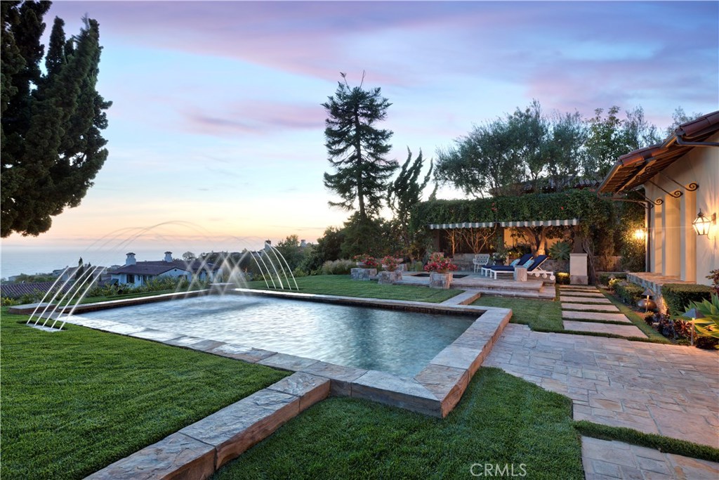 Perched behind the exclusive gates of Crystal Cove, 14 Cruisers Bluff sits on one of the most spacious, private and view-oriented lots. Unobstructed ocean and Catalina vistas are showcased everywhere inside and outside this magnificent estate. A fresh contemporary interior blends seamlessly with the soft Mediterranean architecture and impeccably maintained grounds. Every day feels like a luxurious vacation at this masterfully designed abode. A thoughtful interior layout offers a main-level master suite and two additional guest suites, with den and two additional guest bedrooms upstairs. The magazine-ready kitchen includes rich designer finishes and an open floor plan leading into the dining and family room. The master suite features a beautiful curved tray ceiling and French door access to the fireside courtyard and backyard, framing the view of luscious greenery and sparkling ocean beyond. A resort-like yard includes a grandiose salt water pool clad with impressive arched fountain features, a private heated pergola and barbecue kitchen, and fresh citrus trees lining the picturesque side garden. Cruisers Bluff undoubtedly embodies the most desired aspects of coastal living.