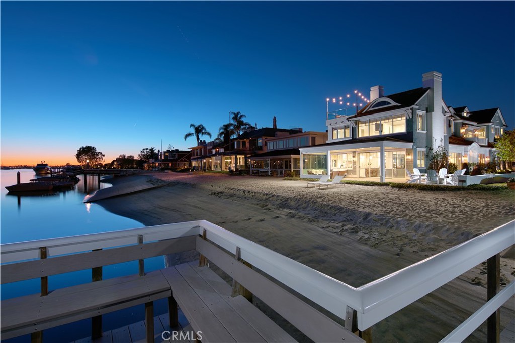 A coastal sanctuary like no other, this extraordinary waterfront estate within the prestigious Beacon Bay community offers a harmonious blend of architectural brilliance and resort-style living. Perched beside a serene sandy bay beach, the home is an impeccable embodiment of the premier coastal lifestyle, seamlessly merging elegance and comfort. Through a welcoming Dutch-door entry, you’re greeted by a sunlit open floor plan adorned with French oak hardwood floors, designer pendant lighting, and intricately crafted crown molding, all exuding timeless sophistication.
Designed to cater to every indulgence, the estate features four lavish bedroom suites, a music room graced by a Baby Grand Piano, and an array of inviting outdoor seating areas. For connoisseurs, two temperature-controlled wine displays and an elevator connecting all three levels elevate convenience and luxury. The chef's kitchen is a masterpiece of form and function, boasting marble countertops, Wolf, Miele, and SubZero appliances, a butler's pantry, a warming drawer, and refrigerated beverage drawers—ideal for creating culinary delights with ease. The primary suite offers a front-row seat to breathtaking water views and a spa-inspired retreat featuring custom tilework, a steam shower, heated floors, and a towel warmer for ultimate relaxation. On the third level, a media room with a kitchenette opens to a rooftop deck complete with a spa, providing the perfect vantage point for soaking in the vibrant hues of a bayfront sunset. Beyond the home’s walls, residents enjoy an unparalleled array of amenities, including beach loungers, stand-up paddleboards, a double kayak, beach and electric bikes, and access to tennis courts. Whether entertaining on the rooftop deck, gliding through tranquil bay waters, or simply unwinding in this coastal haven, every moment here is an invitation to live beautifully. Enhanced by modern conveniences such as Wifi and security systems, this beachside paradise is truly in a class of its own.