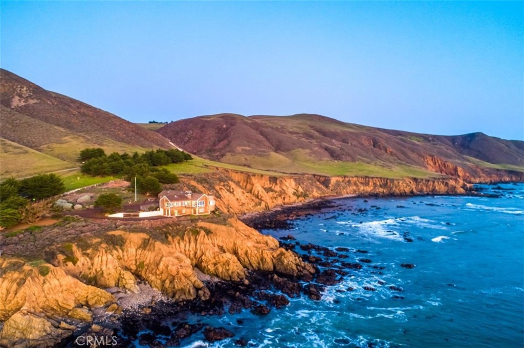Your epic journey on the stunning 480 +/- acre ocean Ranch begins through the gate off of Pacific Coast Highway. Located a mile South of Cambria and 10 miles North of Cayucos, the Ranch starts at the end of HWY 46 West at PCH. Through the gate, we pass a caretakers quarters & distinctive red barn. Continuing up the road we begin the gentle ascent to the ridgeline. A peaceful sense of anticipation builds as you soak in the stunning vistas of the Central Coast. Cresting the ridge you see & feel the sunlight dancing on the Pacific. Everything starts to slow down. The home comes into view as we roll through the gated entry, where the ocean seems to blend with the property. You, the home & ocean are all connected. This feeling remains until we leave the home. Built by a top Central Coast Craftsman in 1990, the 4,000 +/- sf classic estate sits mightily on the coastline bluffs, with miles of unobstructed views. The quality of the home compliments the building site & enhances the marine experience. There is a strong sense of physical & emotional well-being in the home. Majestic views in every room create a feeling of being on a luxury ocean liner. Even the lower garage & craft shop have epic vistas that clear the mind & heighten the senses. The home has alcoves, nooks, reading and gathering areas that warmly flow, connecting one to the water. Outside the flow is enhanced with decks, steps & pathways to explore your world of 480 +/- enchanting acres, however you choose to enjoy it.
