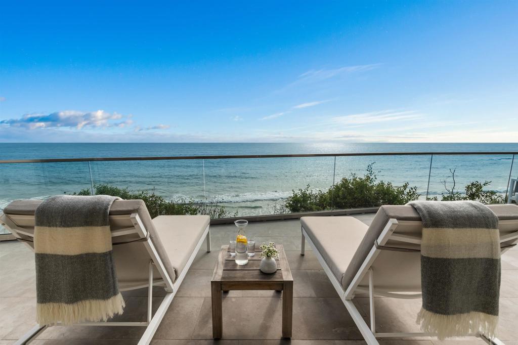 Enjoy the coastal lifestyle in this luxurious contemporary retreat with sweeping dramatic views of the majestic Pacific. The home was totally rebuilt in 2017 with impeccable detail and thoughtfully curated architecture. Interior design elements include vaulted ceilings, high gloss shiplap paneled walls and doors, gorgeous limestone flooring with infrared heating throughout, designer lighting, and floor-to-ceiling sliding doors and windows. The sleek kitchen is appointed with custom cabinetry, Miele appliances, stylish countertops, and a large island. The spacious great room with breathtaking marble feature wall flows into the serene patio area with infrared heating, Barbeque, al fresco dining space, TV, fire pit, jacuzzi hot tub and outdoor shower. There are 3 inviting bedrooms with adjoining full baths, one with dual floating vanity sinks and a magnificent ombre glass shower wall. The entire second level is the tranquil primary bedroom suite, complete with ample closet storage, sumptuous bath, a soaking tub, and a private heated patio with picturesque ocean views. Fully equipped with security, Savant AV, Lutron lighting and shade control systems. Garage with generous storage for bikes, beach gear and surfboards. Offered fully furnished and accessorized for the ultimate in convenience. Steps to the sand, Cedros Design District, Del Mar Racetrack, restaurants, and coffee shops.