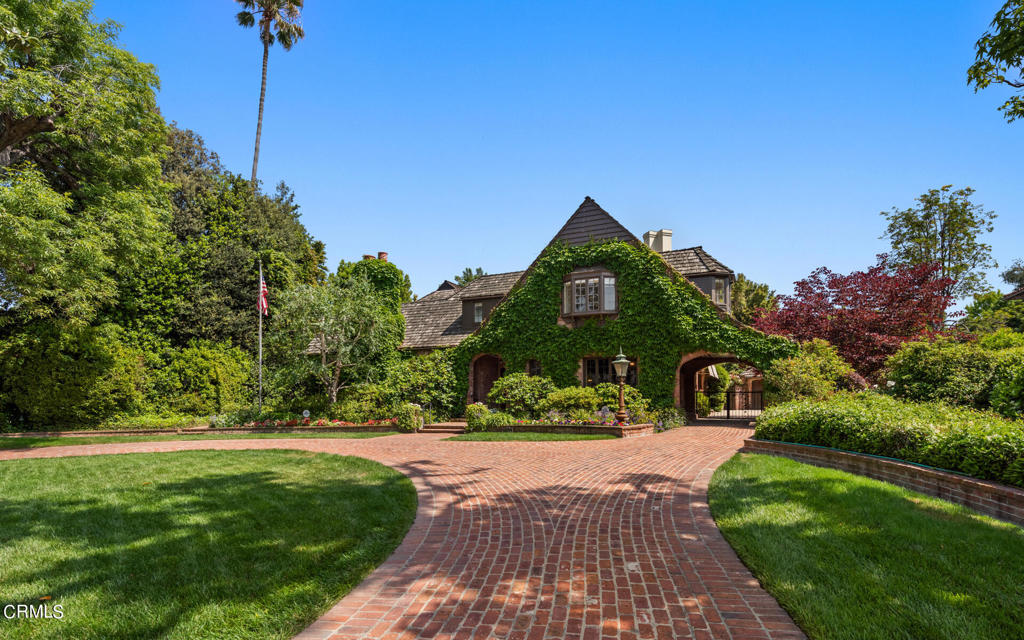 The H. L. Miller House, 1930 -J. Cyrill Bennett & Fitch H. Haskell, AIA. Located in the prestigious Huntington Library estate area of San Marino, this stately Tudor Revival mansion was designed by architects Bennett & Haskell, a highly recognized team dating back to the early 1900's with significant architectural works including the Pasadena Civic Auditorium and many notable private residences. Built in 1930, the brick veneer and plaster home features 6 bedrooms/6 bathrooms, including a primary suite with double vanities and privacy WC, 4 additional spacious bedrooms with 2 shared bathrooms upstairs, and an additional suite on entry level. A beautiful arched brick entry welcomes you through the mahogany front door to the reception hall, flanked by a formal living room with high beamed ceilings and an abundance of windows, a formal dining room with wainscoating, a powder room, and a wood paneled library with hidden bar. The bright and sunny kitchen opens to a breakfast room overlooking the back terrace and gardens and a spacious mudroom/laundry. High ceilings, original oak flooring, and fireplaces in public rooms allow for gracious entertaining. An addition to the house in 1964 was designed by Cyrill Bennett's son Robert E. Bennett, AIA, and includes a spacious family/game room and bathroom. With large front and rear yards, the circular brick driveway leads from the expansive front lawn through a lovely porte-cochere with curved brick walls leading down to the gates on each side. There is a large 2-car garage with the original chauffeur's quarters attached and plenty of room for extra parking. A fully gated rear yard with terrace, pool, spa, original brick fireplace/BBQ, and beautiful rose gardens throughout complete the backyard. Located one block from the Huntington Library, Art Museum and Botanical Gardens, 2200 Orlando Road, with its original architecture and impressive pedigree, is a worthy contribution to this exclusive architecturally rich neighborhood.