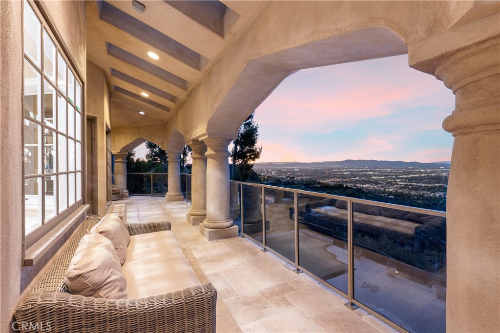 Introducing an impressive French Chateau perched on the crest of one of the most scenic roads in the U.S., Mulholland Drive. Perfectly poised for outstanding 360-degree views from ocean sunsets to sparkling city lights and the Santa Monica mountain skyline.
Enter through double doors into the dramatic 2-story foyer that immediately captivates with a stunning dining room, a gorgeous winding staircase, and natural light pouring in from its 30-foot windows. Offering an unmatched living experience, the Chateau features three breathtaking balconies of expansive views.
Boasting over 9,300 square feet of an idyllic layout that balances spaciousness with warmth. This iconic home offers three beautiful living rooms, formal and informal dining rooms, 5 bedrooms, 7 bathrooms, and 5 uniquely stunning fireplaces. The primary bedroom is a luxurious retreat with a romantic fireplace, a scenic sitting area, an oversized hot tub with 180-degree views, two separate en-suite baths, two walk-in closets, and French doors that lead you to an incredibly serene balcony that takes you a world away. The kitchen is outfitted with top-of-the-line appliances, a large stone island, and a curved wall of elegant french windows that make for an exceptional dining experience.
Distinguished details include soaring ceilings, limestone floors, and an alluring library of rich solid redwood with a majestic hand-carved fireplace and unparalleled city views. Set behind a private gate, on 3/4 of an acre, complete with lush landscaping, a putting green, swimming pool, spa, pool recreation room with shower, plus an outdoor kitchen with built-in barbecue overlooking the fireplace and ambient waterfall. The property also offers garage space for 3 cars and driveway space for six more. This iconic property is one of a kind and sits above some of the most exclusive neighborhoods in the world.