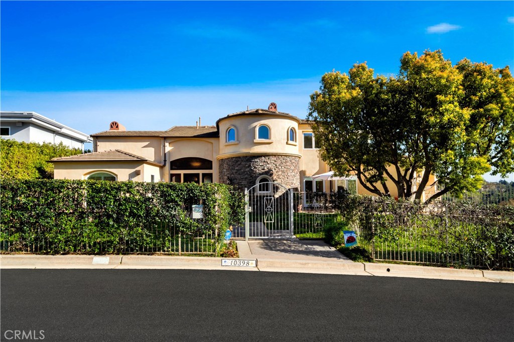 Please note the address on the curb is 10398. We do not want you to miss this home! This tuscany-inspired custom home sits on over an acre of land with multiple viewing decks with views from the mountains to the east and the ocean to the west. See Catalina on a clear day and enjoy the magnificent sunsets in the evenings. 3 levels of resort living, the property is gated with a private yard and patio to enjoy your morning coffee or evening sunset views. The entry leads to a formal dining room and a living room with a marble fireplace and soaring ceilings. Two main-level bedrooms and en suite baths are perfect for the in-laws or guests. There is a chef's kitchen, which features maple cabinets, granite counters, and all stainless viking and bosch appliances, including a large side-by-side refrigerator freezer, six burner cooktop with a center burner, and a large commercial-grade viking range hood that sits on a huge granite island with four chairs and cabinetry work. A double oven, 2 dishwashers, and lots of counter space, including a breakfast bar with a convenient butler pantry, wine center, and beverage refrigerator. Step out to the kitchen balcony to enjoy alfresco meals or the dining room. There is a guest bath on the main floor and a large family room with a built-in media center with a marble fireplace and views of Orange County. The lower level features two bedrooms with en suite baths and a laundry center with a sink. The outdoor deck has a storage garage for seasonal items and outdoor fixtures. The staircase leads to the upper floor, with an art exhibit area and an office or retreat area. The primary bedroom has vaulted ceilings, a fireplace, an en suite bath featuring a spa jetted tub, a huge walk-in shower, and three closets; one of the closets has a large walk-in and dual sinks. The primary bedroom deck has a view of Catalina. Each level has its own heating and air conditioning. A concrete tile roof will last a lifetime, and the copper gutters direct the rainwater away from the house. This home is located in Cowan Heights, with the best schools, including Foothill High School, and a gated front yard for pets or kids. The house features an oversized 3-car garage with an epoxy floor, plus an extra large driveway and plenty of street parking.