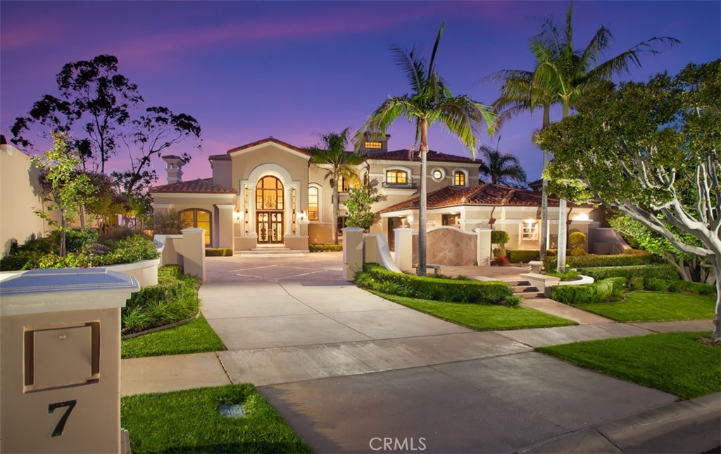 Situated behind the guard-gated community of Pelican Ridge Estates, this (approx.) 4600 sq foot custom residence boasts breathtaking city lights views and magnificent mountain-top vistas from nearly every room. An oversized motor-court, incredible frontage, and unparalleled privacy, characterize 7 Seahaven as a proper custom estate. Recently updated and highlighted by luxurious finishes, including hand-crafted cabinetry, Creme de Marfil marble floors, soaring ceilings, and gleaming chandeliers....no expense was spared in the construction of this home. The functional floor plan offers a main floor bedroom, an executive home office, 3 bathrooms and two formal living spaces. The gourmet chef's kitchen flows seamlessly into the grand family room that is complimented by crystal light fixtures throughout and direct access to you breathtaking backyard showcasing incredible sit-down city light and partial ocean views. Bask in the comfort of the spacious master suite and relish the warmth of a roaring fire as you take in the sprawling views from your very own private retreat and enjoy your spa like bath. Angelic, seasonal flowers & lush greenery envelop the outdoor space which hosts multiple sitting areas, a BBQ island, a newly added pergola, and allows for seamless indoor/outdoor living. A 3-car garage, private motor court, extraordinary curb appeal, exceptional schools, world class shopping & dining, as well as 24hr guard gated security round this home off as the ideal residence for the most discerning buyer.