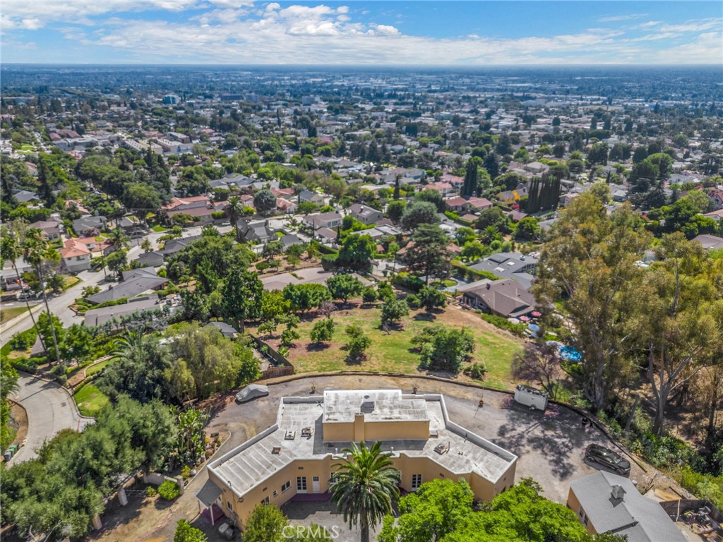 Nestled atop a hill, this exquisite 1920s Italian Villa estate offers 180 degree breathtaking views of the city from L.A. to Orange County and peaceful views of the Turnbull Canyon Hills. Spanning approximately 3,350 sq ft this home sits on on a generous estate sized lot. This expansive property offers a 2 parcel lot (additional parcel # 8126-041-003) with an opportunity to build another home. The grand living room exudes warmth and charm, featuring a marble fireplace, crown molding, a coved ceiling, and original hardwood floors. French doors provide an abundance of natural light and frame the stunning views. From the living room, French doors lead to a spacious and peaceful sunroom, perfect for relaxing and enjoying the surrounding beauty.
The formal dining room, continues the crown molding and large French window doors. Living and dining room flow seamlessly into each other , making it ideal for entertaining guests while taking in the panoramic views. The kitchen is a chef's delight, complete with a butler's pantry, ample cabinet space, elegant marble countertops, and large picture windows with views of the city.
This estate features five bedrooms and three and a half bathrooms. Two of the bedrooms are connected by a charming Jack-and-Jill bathroom with a classic clawfoot tub and old world charm. The third bedroom has a light and airy resort feel, French door windows, captivating views, and a spacious layout. It includes a beautiful en-suite bathroom, providing a possible downstairs primary suite. The fourth bedroom is presently used as an office with peaceful views of the hills and trees.
Ascend the gorgeous tile staircase to the primary bedroom, a true sanctuary with sweeping city views, double walk-in closets, and a luxurious private bath featuring a charming clawfoot tub. From here, step out onto the rooftop deck to savor the incredible views, enjoy breathtaking sunsets, watch the Disneyland fireworks, or see the cruise ships leave Long Beach. The property also has a finished basement, a guest house, garage work area, and a storage shelter that could be the perfect wine cellar. Located minutes away from the charming Uptown Whittier with a variety of restaurants and shops to enjoy. A short walk down your driveway and you are on the trails of Turnbull Canyon. Don't miss the unique opportunity to own a 100 year old home that blends timeless elegance and modern comfort amongst the preserved small-town charm that makes Uptown Whittier so special.