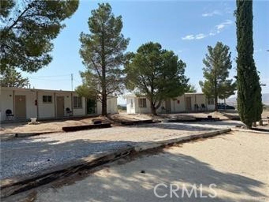 This mid century style property includes 9 buildings spread out across nearly 9 acres with plenty of room for expansion and parking. Remote and private location. The property includes 7 residential units which currently have two single beds and a bathroom with a shower. An eighth building includes a nicely equipped kitchen, dining room with seating for 24, two additional bedrooms, two offices and a spacious living area.  A ninth building includes a medical office, and a bathroom with a shower.  The property includes a water well which is inspected by the state annually. Gas, Electricity, and 5 septic tanks provide the utilities for this location. Make your dream a reality!