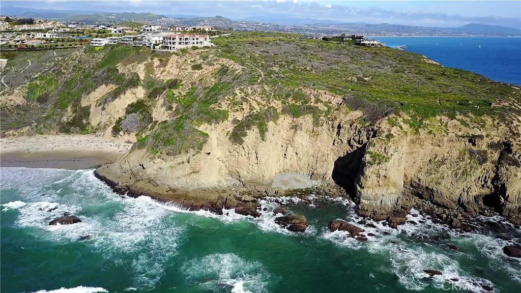 Meticulously crafted for the discriminating buyer, this residence displays all the characteristics and qualities for a resort lifestyle. The preeminent location is situated on the Headlands between Dana Point Harbor and the Ritz Carlton and Monarch Beach Resorts, and soars high above Strands Beach below and bordering the Headlands Preserve, enabling unimpeded northern coastline vistas to Palos Verdes, westward to the Pacific Ocean and Catalina and southward to San Diego. The panoramas rival any along the California coastline. Sophistication through pampered elegance is evident from the moment you enter this distinctive accommodation. Characterized by its 3 en-suite bedrooms including a luxurious master suite, dramatic open floor plan, gastronome kitchen, 600 bottle glass encased and temperature controlled wine closet, Control 4 smart house system and 7-car subterranean garage. Privacy is prevalent with gated entry and multiple security cameras surrounding the property. A distinctive feature is its glass walled backyard perched above the waves crashing against the beach cove below. Strands Beach access is within 100 feet of your front door, as is the 30 acres Headlands Preserve with scenic walking paths to the harbor. Take a stroll along the beach path and enjoy the resort amenities including the world class spa and golf course and multiple restaurant locations. You must see to believe all this setting has to offer.