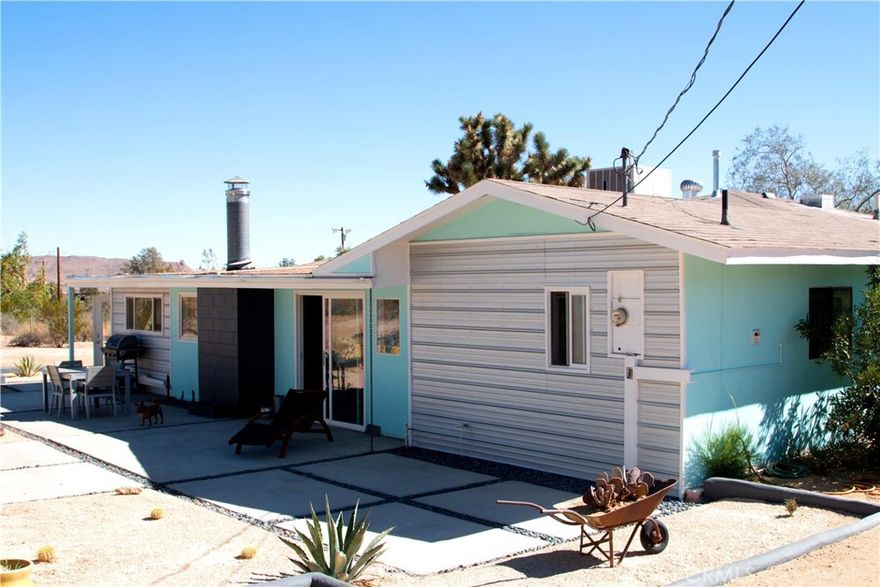 Charming mid-century home with income producing guest house in central Yucca Valley on large lot!  From the moment you pull into the long circular drive, surrounded by mature vegetation, you already feel like you're removed from town. Head up to the main house with its designer paint colors and corrugated metal accents and you can quickly sense the creative spirit that flows throughout this unique property.  The front house features two bedrooms, two baths, an updated kitchen and bath, a fireplace in the rear lounge, two car garage and spacious rear patio and garden area with hot tub.  The fenced backyard has a drive-through gate leading to the one bedroom + one bath casita at the rear of the property, which has been a successful vacation rental.  A corrugated metal privacy fence separates casita from front house, creating a separation of space between the two homes.  Beside the casita is a 500 square foot detached garage/workshop, which has been recently drywalled, giving you even more space to work with on this exceptional property.  So many options here - two income producing vacation rentals, a full term residence with mother in law, an artist retreat - let your imagination run wild!  Call today to schedule your showing.