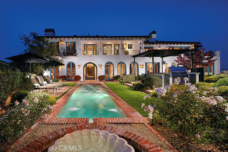 Situated on the premier view lot in prestigious Pelican Point, this gracious Spanish Colonial style custom residence is reminiscent of the great estates of Santa Barbara and Montecito. The private 15,000 sq. ft. parcel is situated on an elevated corner and takes in panoramas of the adjacent fairways, the coastline from Palos Verdes to Laguna, and the ocean and Catalina beyond. This unique vantage point captures the beaches of Newport as well as the coves and city lights of Laguna. The exquisite yet understated residence is near to 9,000 sq. ft. and includes every desirable amenity. Generously-scaled public rooms all open through walls of French doors to the gardens and ocean views. The formal gardens are complemented by a beautiful pool and view terraces, intermingled within the meticulously maintained grounds. The master suite (one of five bedroom suites) includes an ocean view study, a large terrace, as well as sumptuous bath and dressing area. The tasteful interior appointments were designed by Concept Studio, and include the very finest materials. There is also a 2,000 sq. ft. subterranean garage and elevator. Pelican Point is an exclusive, guard-gated, community on the ocean, south of Corona del Mar. Residents have private access to miles of beaches.