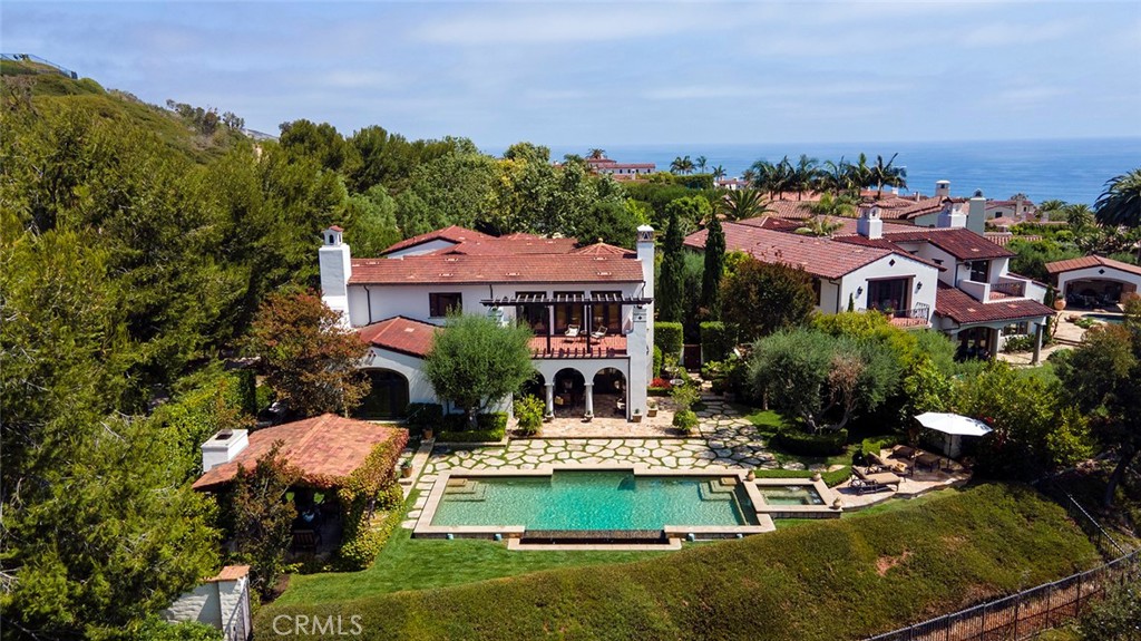 Located in the premier coastal community of Crystal Cove, One Ocean Bluff offers a tranquil setting of casual elegance, complete privacy and comfort. This prime end of cul-de-sac property is on a rare street of only 5 homes and is situated on an oversized lot, approximately 15,000 sq. ft. The unique 5,000+ sq. ft. Santa Barbara-inspired estate features extensive grounds covered with lush landscaping, outlined with stately pine trees for added solitude. A spacious floor plan allows all major rooms to overlook the gorgeous oversized grounds toward ocean and canyon views.
The formal living room and dining room open to a covered loggia allowing for year-round indoor/outdoor entertaining. Handsome stone floors lead you to the great room and cozy morning room with vaulted beamed ceilings & crackling fireplace. The adjoining chef’s kitchen and butler’s pantry, with professional grade appliances, are the heart of the home and the ideal gathering place. A beautiful wood paneled office with built-in bookcase and coffered ceiling, as well as a spacious main floor guest bedroom suite with private direct exterior access completes the main level.
A second floor features a generous Master suite with dramatic barrel ceiling, private ocean view terrace, and luxurious bath with dual vanities and dual walk-in closets. Two additional bedroom suites and a large media/bonus room with exterior access and could be bedroom #5 completes the second floor.
The garden features a beautiful pool and spa, an inviting cabana & fireplace- the perfect spot to watch coastal sunsets, a built-in BBQ area and grassy lawn which are all secured behind the courtyard entrance gate, providing a private and secluded atmosphere. This prime end of cul-de-sac location is on a rare street of only 5 homes.
Offered freshly painted and newly carpeted in turn-key, move-in condition with
Oversized 3 Car Garage, Whole house Audio/Visual Security System and Central Vacuum.