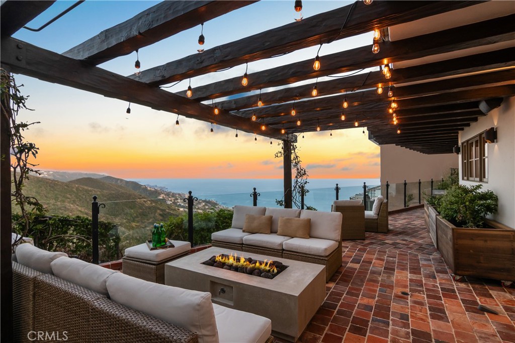 This European-inspired villa is unlike any other. Just one mile from Southern California's best beaches, this enchanting retreat whispers stories of timeless elegance with authentic 300-year-old French tiles and other exquisite French touches throughout. Rebuilt in 2008 and refreshed in 2024, the home seamlessly blends classic allure and modern living with its 3 beds, 4 baths, and a media room that can easily be converted to a fourth bedroom. A privacy wall encircles the property, creating a secluded sanctuary. The tranquil front courtyard with a water feature welcomes you, while the backyard unveils breathtaking ocean views, a fire pit for starlit evenings, alfresco dining space, and a sprawling terraced garden. Inside, a stunning, unique, and romantic interior awaits. The formal living room beckons with a gas fireplace, while custom details like the iron staircase and mahogany front door whisper of bespoke artistry. The open family room and chef's kitchen, with marble counters and open shelving, frame south-facing ocean vistas just beyond the lush Laguna hillsides. A French La Cornue CornuFe’ 110 range, Sub-Zero fridge, Miele dishwasher, warming drawer, and center island complete this gorgeous kitchen. Upstairs, you will discover three ensuite bedrooms, a laundry room, and the versatile media room. The primary suite boasts canyon and ocean views and a luxurious bath with a glass shower, soaking tub, and a massive walk-in closet. The entire experience is elevated by details and upgrades such as hand-hewn beams, a wine fridge and bar, Sonos sound, a 2-car attached garage with epoxy flooring, 13 solar panels, and 2 Tesla batteries (installed 2022). Located just half a mile from Moulton Meadows Park with trails, sport courts and playgrounds, and a mile from local favorite Victoria Beach, this home offers prime access to Laguna's natural beauty. A short 1.3-mile drive brings you to the famous Montage Resort, or head north to shops, restaurants, and beloved art galleries. This rare masterpiece, curated with care and offering the very best of the Laguna Beach lifestyle, is an opportunity you won't want to miss.