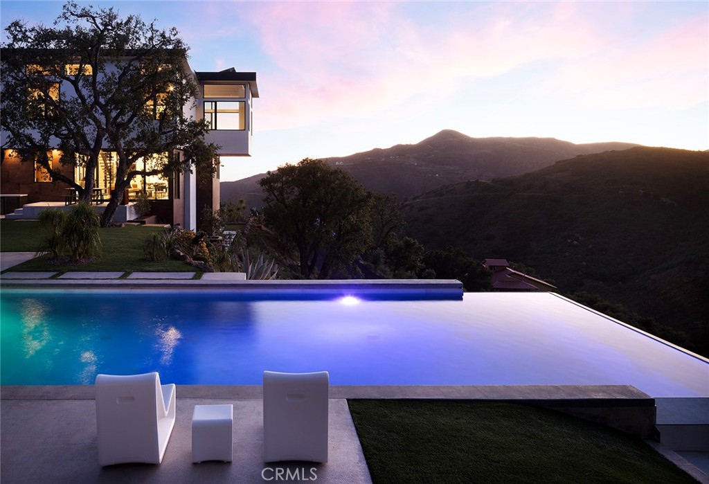 LedgeWater:
A modern architectural masterpiece, LedgeWater graces a pristine 3.8-acre canvas in West Malibu, an exquisite testament to the seamless synergy between AIA award-winning developer Jeff Widmann of Widmann Development and architects Patrick Killen, Howard Crabtree of 912 Architecture, and Leila Bick Design.
This sanctuary of modern design showcases meticulously sourced materials and cutting-edge design elements, crafting a bespoke resort experience:
Privacy reigns supreme, embraced by a custom estate gate and comprehensive automation, introduced by a sweeping private driveway.
A technological marvel, the residence boasts Starlink internet, whole-house water filtration, an 11.3-kilowatt solar system, and 2 Enphase battery backup systems.
All automation, including blanketed Ubiquiti wifi, is integrated into the "Home Kit" system, which includes:
EZ View / Cameras
Heos / Audio
ScreenLogic / Pool Control
Monitoring Center / Security
Resideo / HVAC
Somfy / Shades
Lutron / Lighting
DoorBird / Access
My Power / Solar & Battery
The central glass elevator, a striking centerpiece in the expansive living room, showcases industrial elegance and enhanced livability.
Revel in cinematic indulgence within the private theater, equipped with Focal speakers and a 144” Stewart Screen, all integrated with a state-of-the-art system.
The primary bedroom sanctuary boasts soaring 14-foot ceilings, a custom closet, meticulously book-matched porcelain, a steam shower, a private balcony, awe-inspiring ocean vistas, a grand 85” fireplace, and an 85” Art TV, fitted with state-of-the-art audio.
Adorned with an artfully designed, porcelain and Italian marble layered fireplace coordinated with kitchen book-matched quartz, the living space animates warmth, complemented by beautifully designed furniture and art that enhance the architectural aesthetic.
Outdoors, a limestone-clad 75-foot Jr. Olympic infinity edge pool equipped with an electric cover, passive solar heating, and a Pentair ETi 400k BTU heater with 96% thermal efficiency. Notably, a separate 400sqft multi-purpose structure graces the grounds.
These meticulously crafted elements converge to create a residence that epitomizes modern, supremely livable architecture. The property offers breathtaking ocean and Boney Ridge vistas, a haven where luxury, innovation, and natural beauty harmoniously coexist.