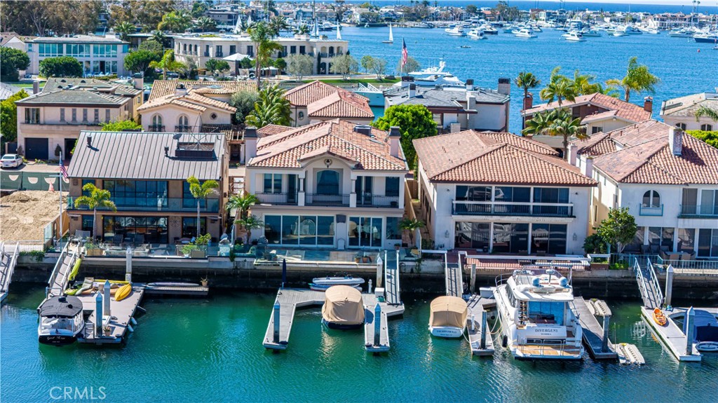 Welcome to your secluded sanctuary in the heart of the highly exclusive, guard-gated community of Linda Isle. This amazing home is nestled within the serene embrace of the private horseshoe shaped bay. This breathtaking 4-BR & 4BA oasis spans over 5,300 square feet of luxurious living space on an expansive 6,000 square foot lot. Arguably the best location on Linda Isle, private on the interior cove, however, easy access to the main channel. This home boasts a downstairs library/study, and an office that can both be converted to additional downstairs BR's.
As you step into this palatial abode, you'll be greeted by an inviting entry foyer adorned with a breathtaking staircase, setting the stage for the elegance that awaits within. The open living space invites natural light to dance through floor-to-ceiling windows, illuminating every corner of this sun-drenched haven. Entertain in style at the exquisite bar convening area, where cocktails flow effortlessly amidst a backdrop of unparalleled bay views. The oversized primary en-suite beckons with the promise of indulgent relaxation, boasting a cozy fireplace, convenient coffee bar, fridge, and sink. With potential space for a gym or additional bedroom, this haven offers limitless possibilities to tailor your desires.
The allure of the bay beckons from every vantage point, with floor-to-ceiling windows in the dining area, kitchen, and family room offering panoramic vistas that will leave you breathless. Upstairs, the second-level en-suite overlooks the bay, offering a serene sanctuary to unwind and soak in the tranquil beauty of your surroundings. Indulge in the exclusive amenities afforded by the HOA, including access to a private beach, guest docks, play areas, and sport courts, ensuring endless opportunities for leisure and recreation right at your doorstep. Bring your Kayak, or SUP and launch of your own private doc. Conveniently located near prestigious destinations such as Fashion Island, Balboa Bay Club, Newport Beach Country Club, and John Wayne Airport, this home offers unparalleled access to world-class dining, shopping, and entertainment options.
Whether you're seeking a serene retreat to unwind and recharge or a lavish backdrop for unforgettable entertaining, this exquisite home offers the perfect blend of luxury, privacy, and unparalleled beauty. Don't miss your chance to make this secluded paradise your own – schedule your private tour today and experience the epitome of NB coastal living!