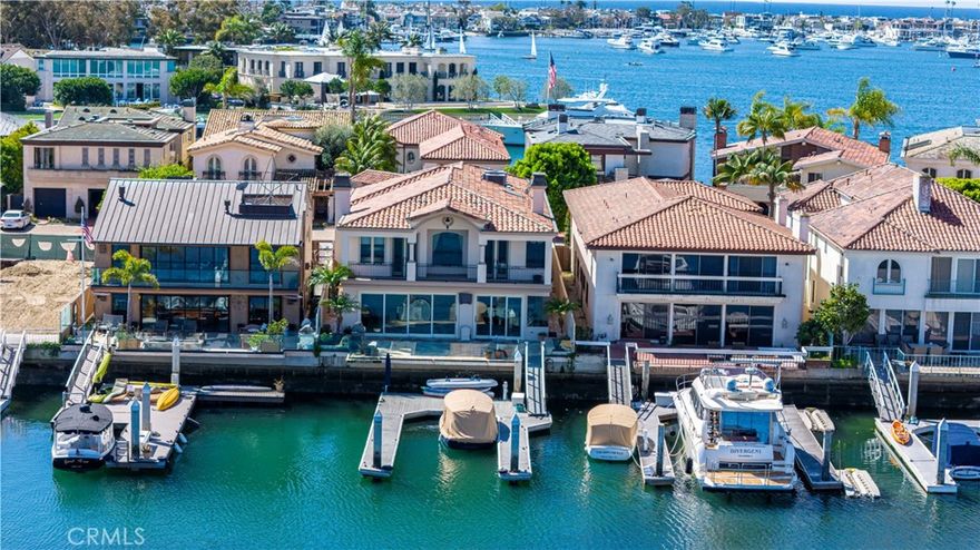 Welcome to your secluded sanctuary in the heart of the highly exclusive, guard-gated community of Linda Isle. This amazing home is nestled within the serene embrace of the private horseshoe shaped bay. This breathtaking 4-BR & 4BA oasis spans over 5,300 square feet of luxurious living space on an expansive  6,000 square foot lot. Arguably the best location on Linda Isle, private on the interior cove, however, easy access to the main channel. This home boasts a downstairs library/study, and an office that can both be converted to additional downstairs BR's. 
As you step into this palatial abode, you'll be greeted by an inviting entry foyer adorned with a breathtaking staircase, setting the stage for the elegance that awaits within. The open living space invites natural light to dance through floor-to-ceiling windows, illuminating every corner of this sun-drenched haven. Entertain in style at the exquisite bar convening area, where cocktails flow effortlessly amidst a backdrop of unparalleled bay views. The oversized primary en-suite beckons with the promise of indulgent relaxation, boasting a cozy fireplace, convenient coffee bar, fridge, and sink. With potential space for a gym or additional bedroom, this haven offers limitless possibilities to tailor your desires.
The allure of the bay beckons from every vantage point, with floor-to-ceiling windows in the dining area, kitchen, and family room offering panoramic vistas that will leave you breathless. Upstairs, the second-level en-suite overlooks the bay, offering a serene sanctuary to unwind and soak in the tranquil beauty of your surroundings. Indulge in the exclusive amenities afforded by the HOA, including access to a private beach, guest docks, play areas, and sport courts, ensuring endless opportunities for leisure and recreation right at your doorstep. Bring your Kayak, or SUP and launch of your own private doc. Conveniently located near prestigious destinations such as Fashion Island, Balboa Bay Club, Newport Beach Country Club, and John Wayne Airport, this home offers unparalleled access to world-class dining, shopping, and entertainment options.
Whether you're seeking a serene retreat to unwind and recharge or a lavish backdrop for unforgettable entertaining, this exquisite home offers the perfect blend of luxury, privacy, and unparalleled beauty. Don't miss your chance to make this secluded paradise your own – schedule your private tour today and experience the epitome of NB coastal living!