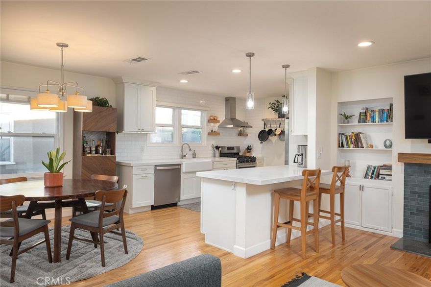 Welcome Home to this lovingly updated modern home on a tree-lined street in Bixby Knolls. Enter into an open, light and bright living room with wood burning fireplace, hardwood floors and recessed lighting that connects seamlessly to the beautifully updated open concept kitchen. Featuring three bedrooms and two-and-one-half baths, central air conditioning and heat with paid off solar panels which helps tremendously with utility bills. The kitchen has been fully remodeled with quartz countertops, a built-in wine fridge and microwave, a farmhouse sink, floating shelves and a spacious pantry.

The impressive primary suite features an enormous walk-in closet and a thoughtfully updated en-suite primary bathroom, complete with a custom built dual vanity, quartz countertops, recessed lighting, glass-enclosed shower and modern open shelving. The hall bathroom has been updated with granite countertops, marble flooring, stand alone bath tub and open glass shower. There is ample storage throughout the home and each room is generously sized.

The lush, private backyard is an oasis of greenery and perfect for entertaining with a large deck, a hot tub and an outdoor shower. The insulated garage is a perfect flex space as a work-from-home office or a home gym. The front yard has been thoughtfully landscaped with drought-tolerant plants for easy maintenance. Additional upgrades include a new electrical panel, upgraded wiring, an electrical vehicle charger, tankless water heater, updated plumbing, and long driveway. Close proximity to parks, shopping, and dining on Atlantic Avenue.